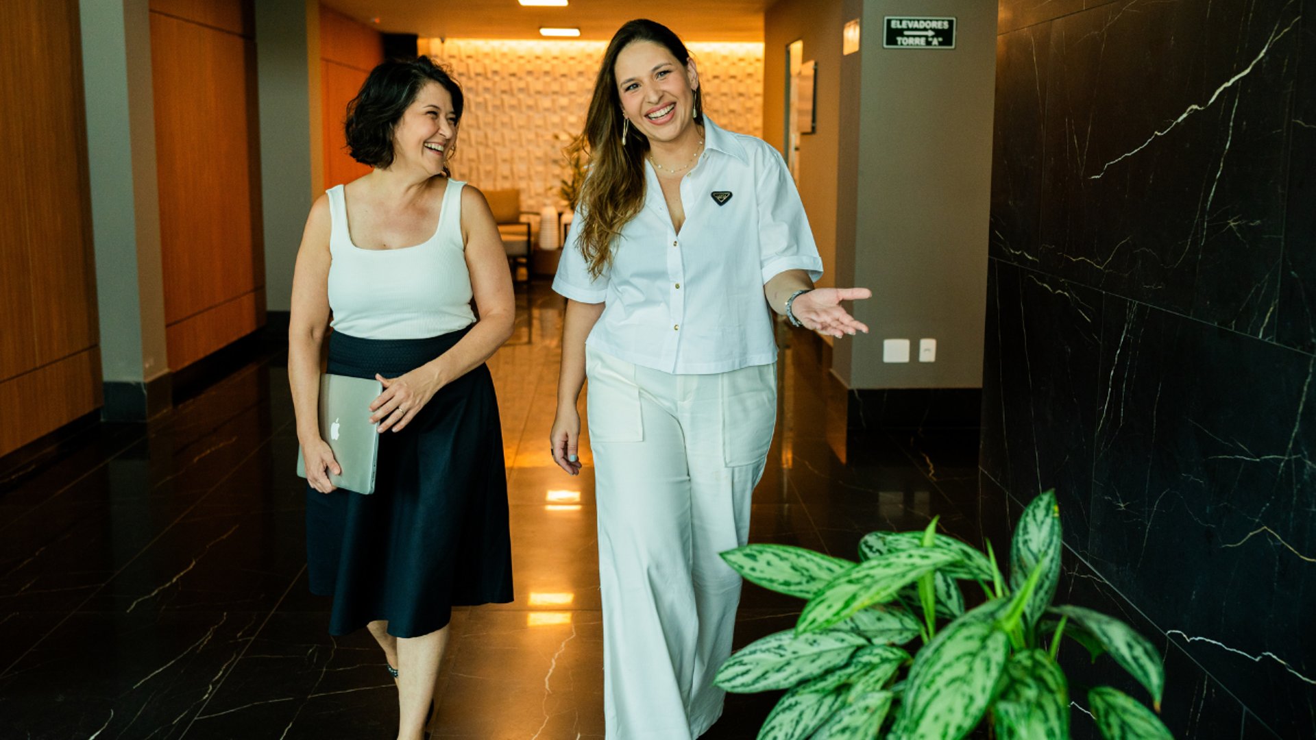 smiling man using laptop computer while sitting on black leather sofa