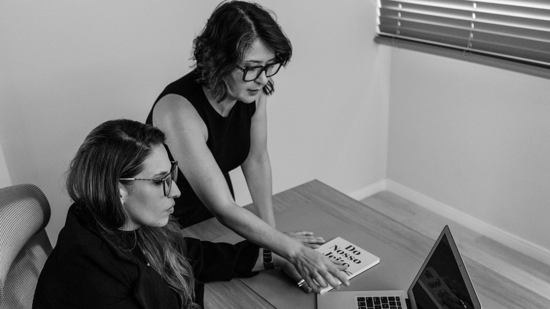 two women sitting on leather chairs in front of table
