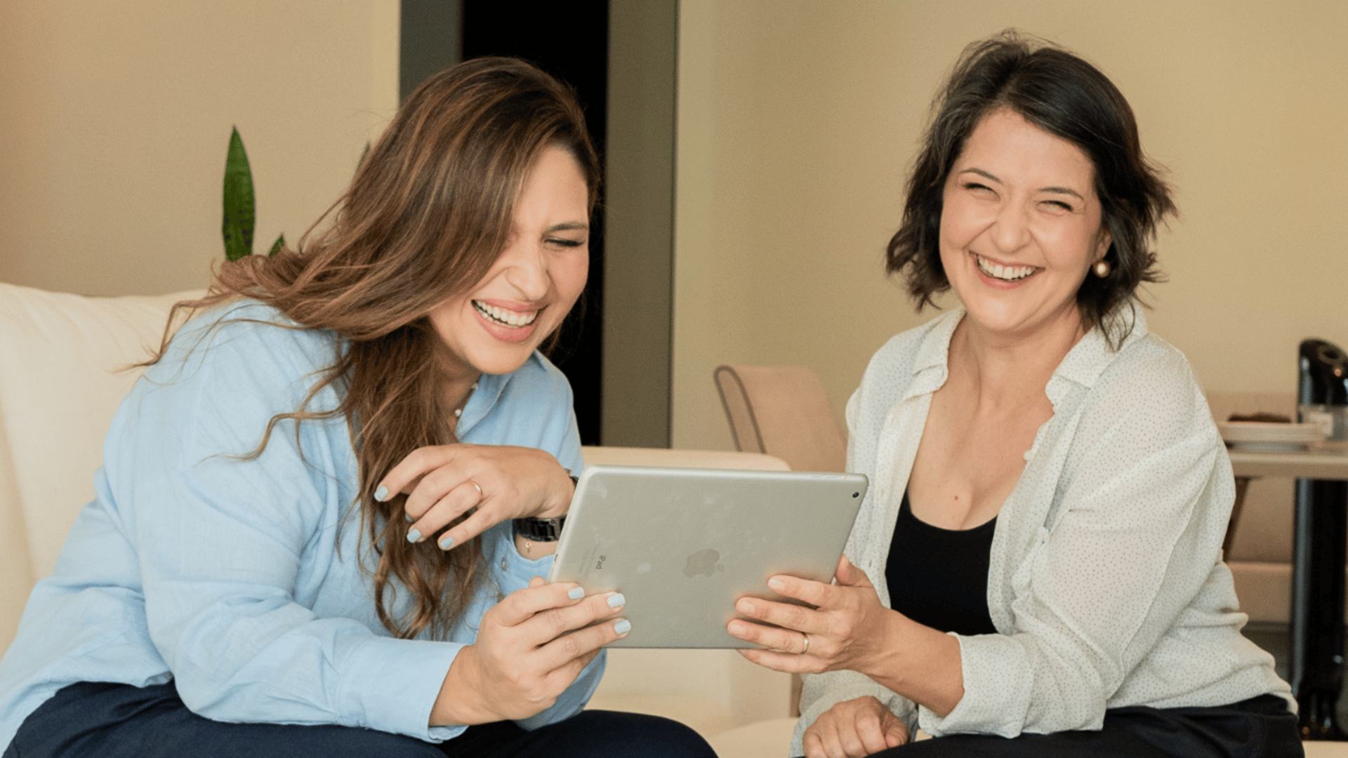 smiling man using laptop computer while sitting on black leather sofa