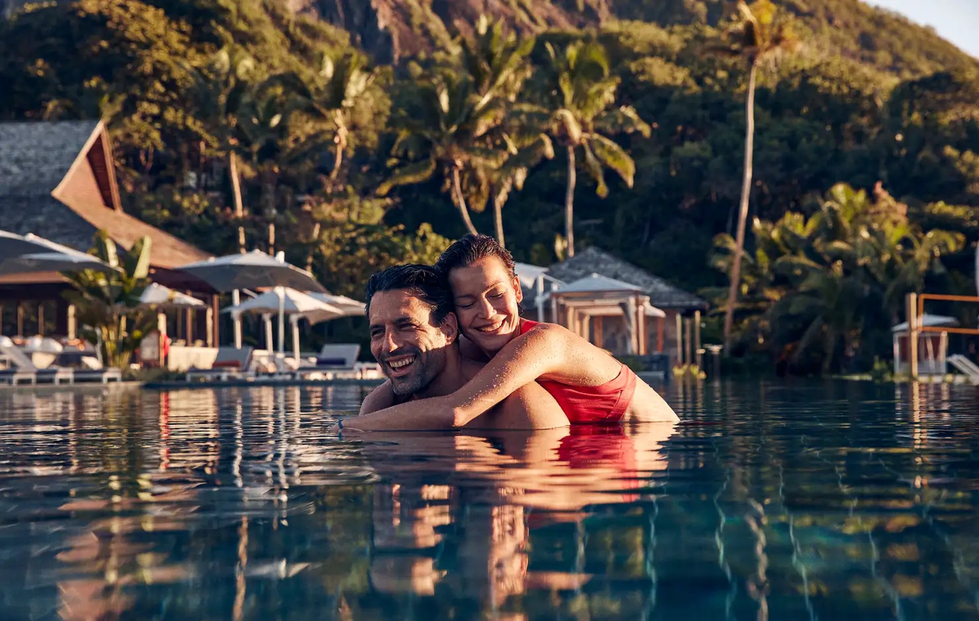 a woman sitting on the ground looking out at the water