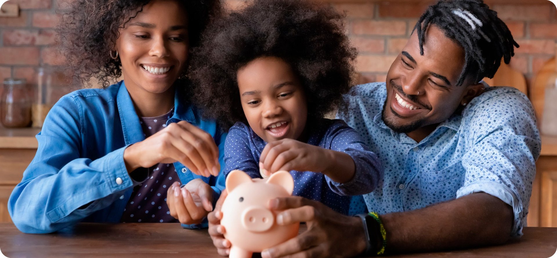Alt Text: Família sorridente ensinando educação financeira a uma criança, colocando moedas em um cofrinho em formato de porqu