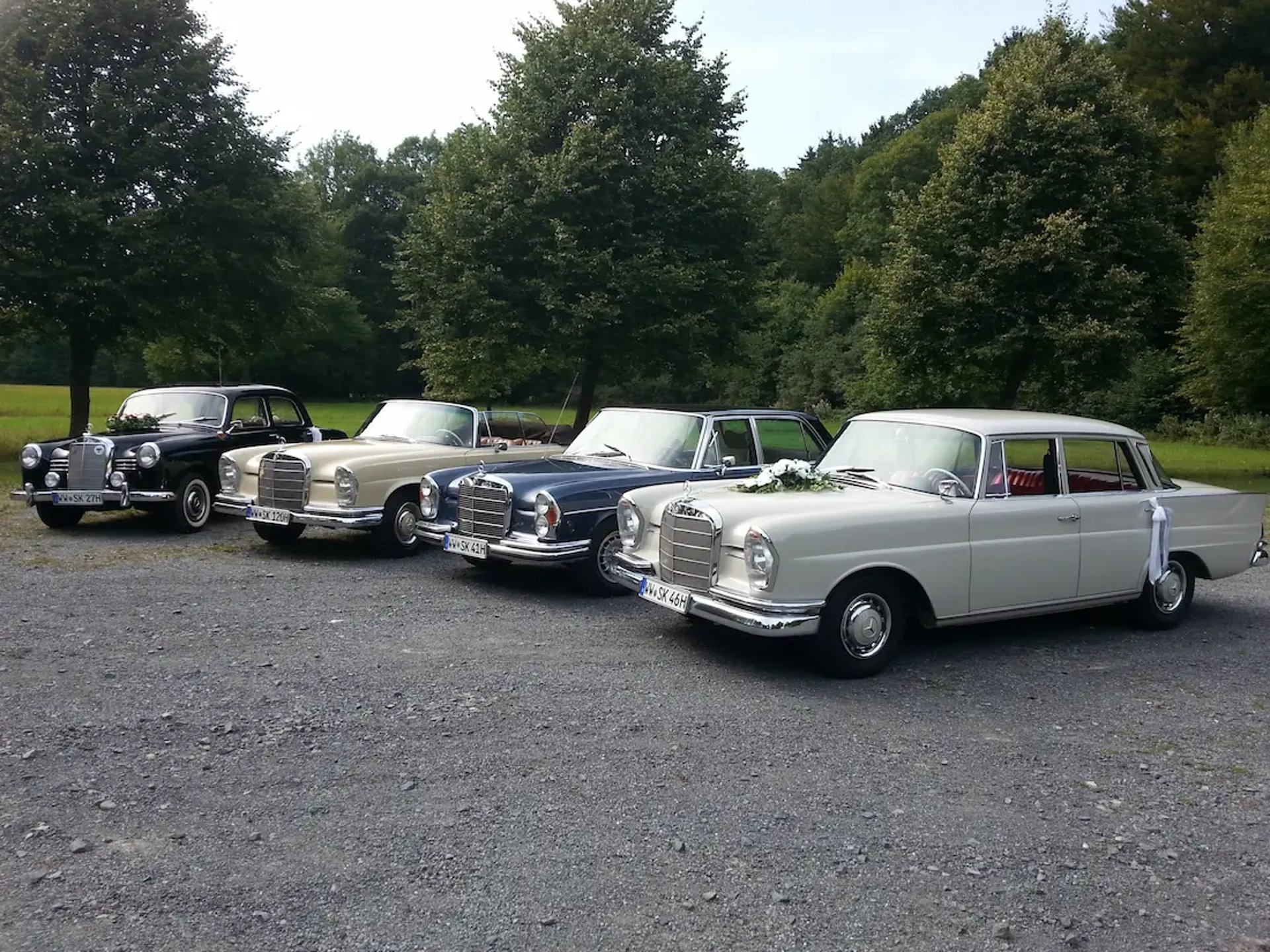 4 Oldtimer stehen in einem Bogen in einer Reihe. 