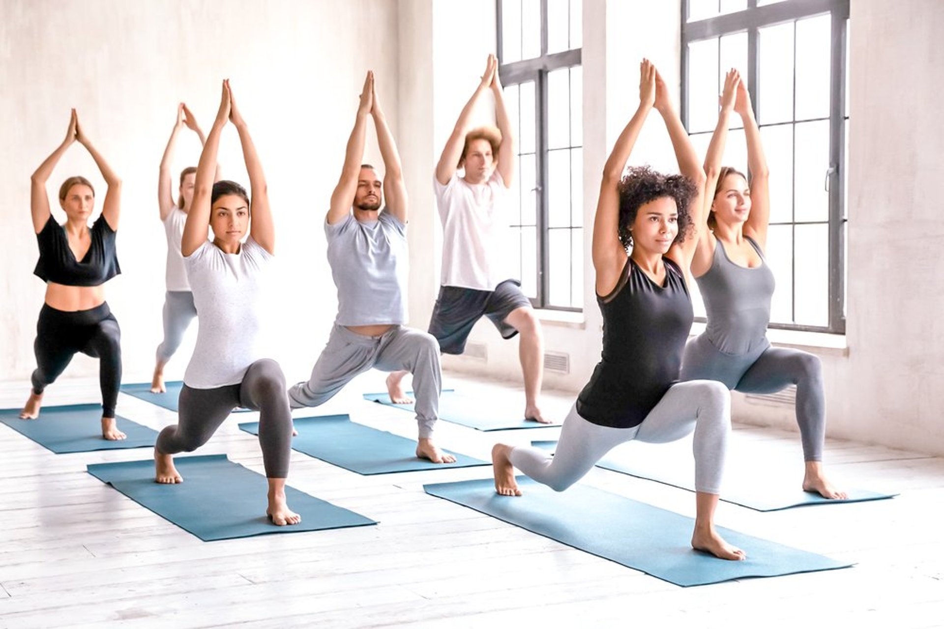 woman in white tank top and pink leggings doing yoga