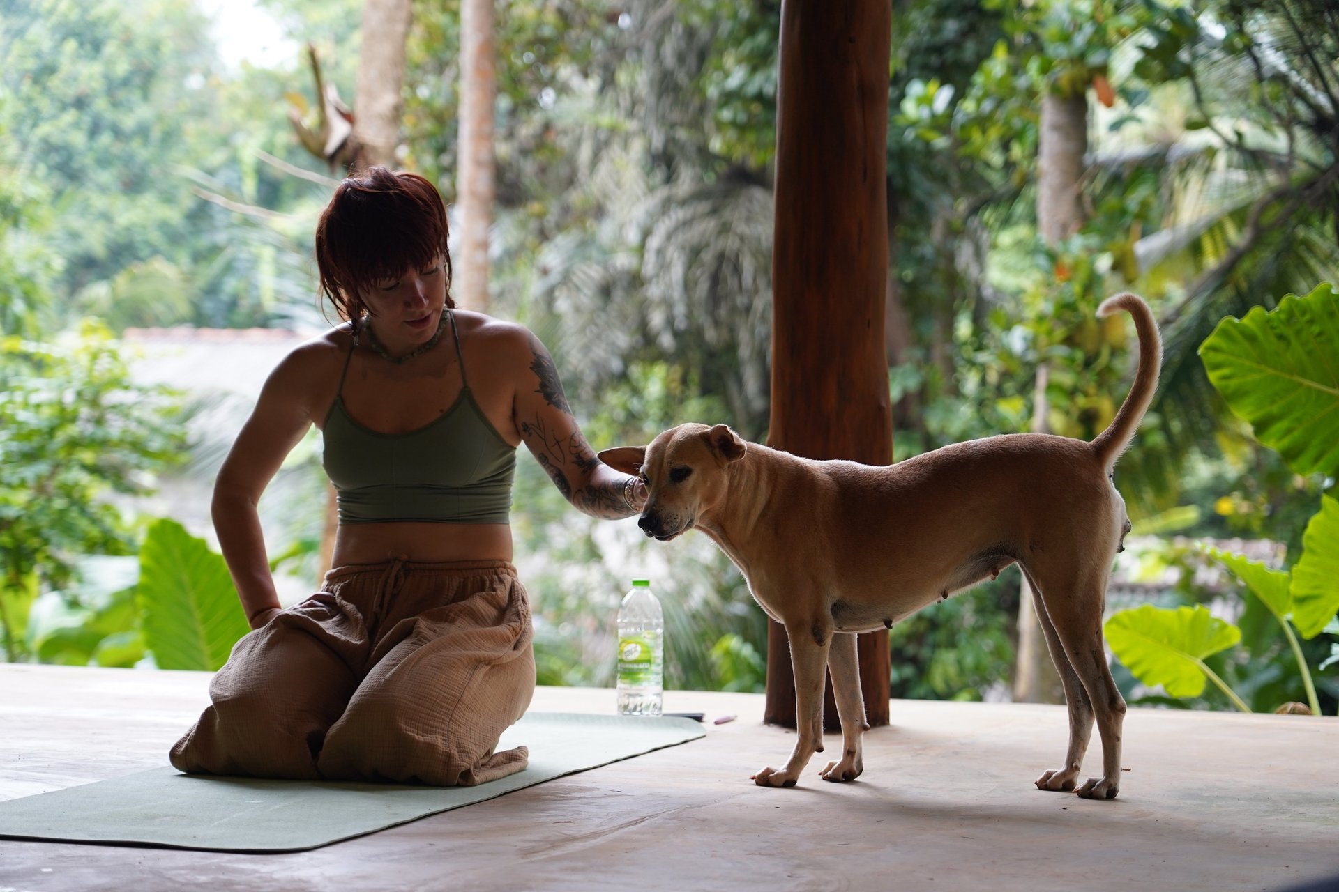 woman in black tank top and black pants bending her body on floor