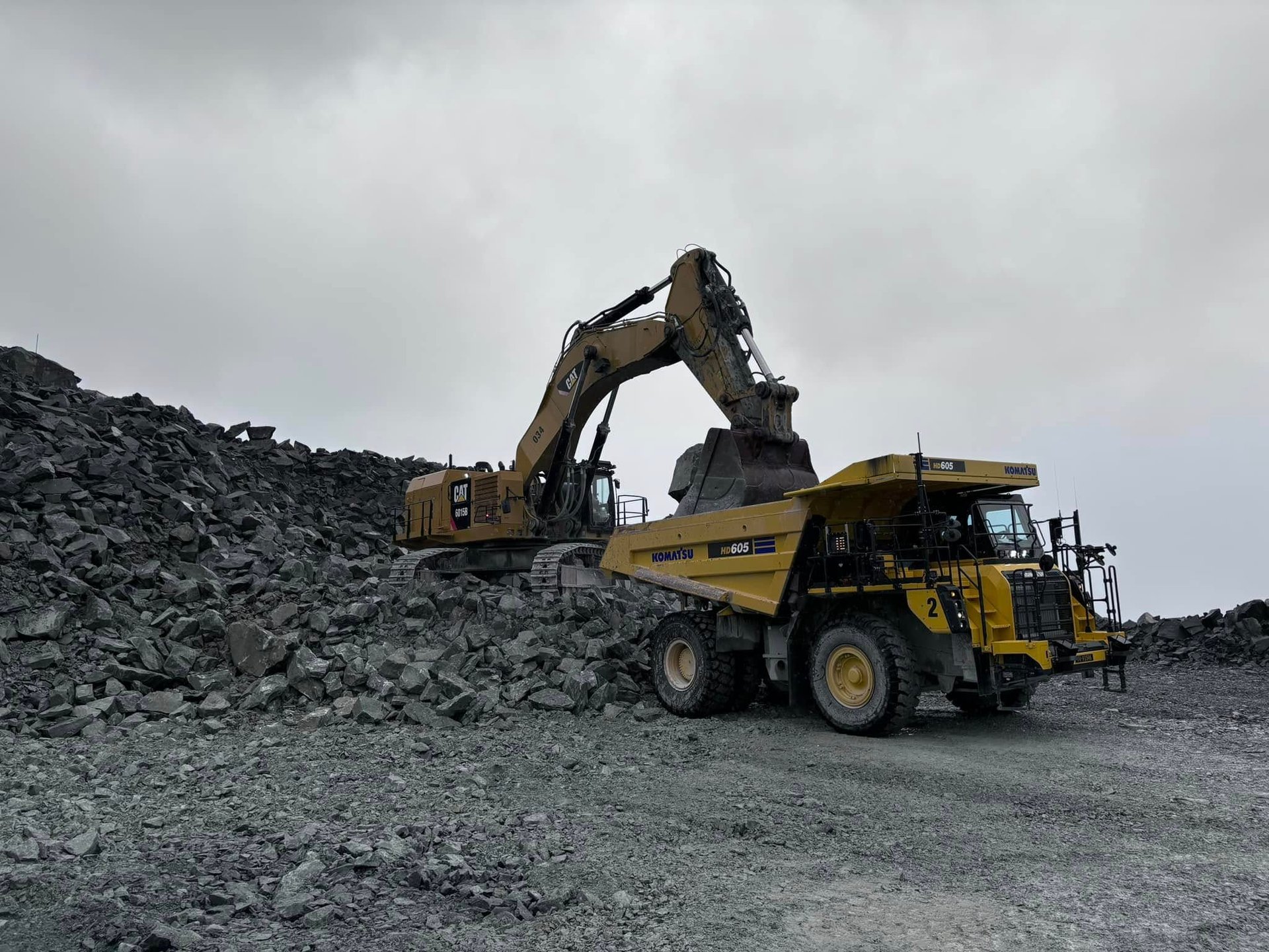 yellow and green excavator on rocky ground during daytime