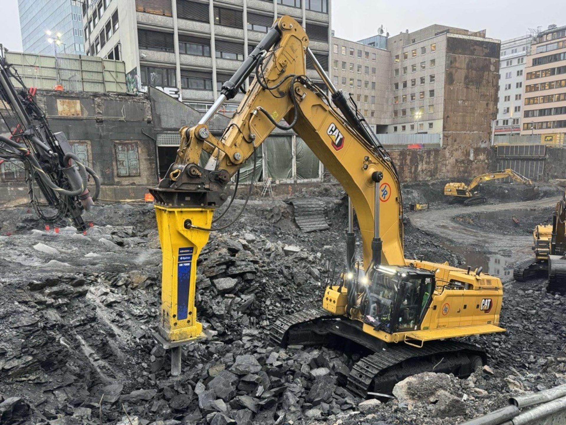 yellow and black excavator on rocky ground