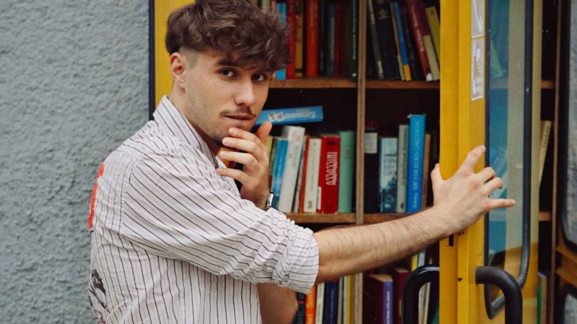 A man standing in front of a yellow book case