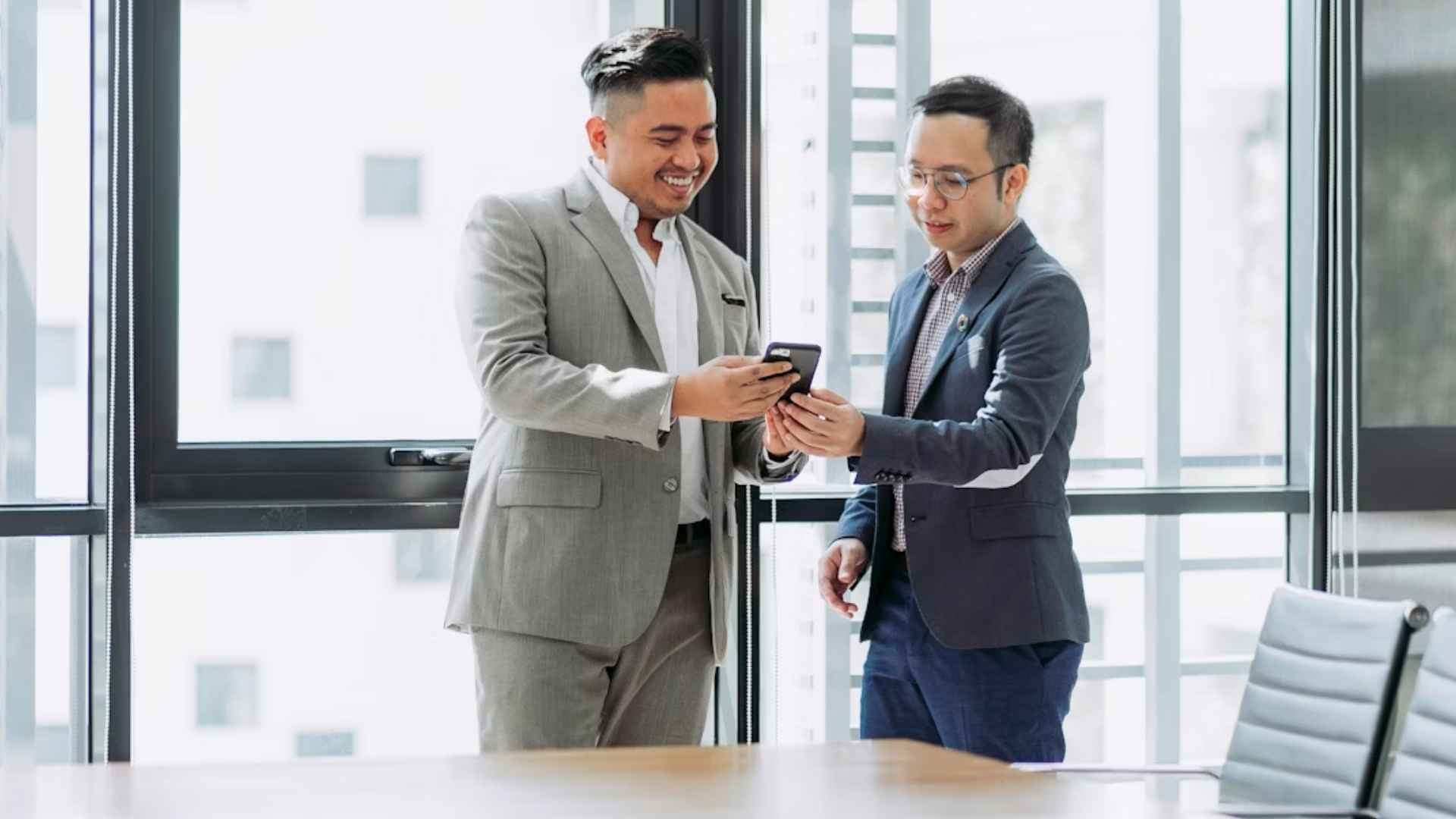 two men shaking hands in a conference room