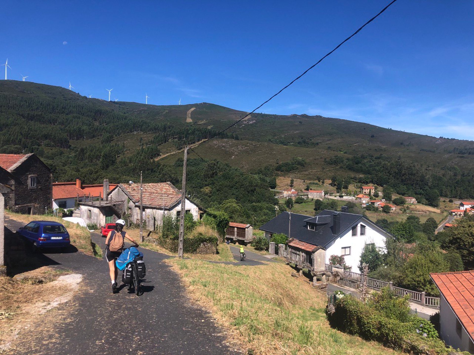 person cycling on road distance with mountain during daytime