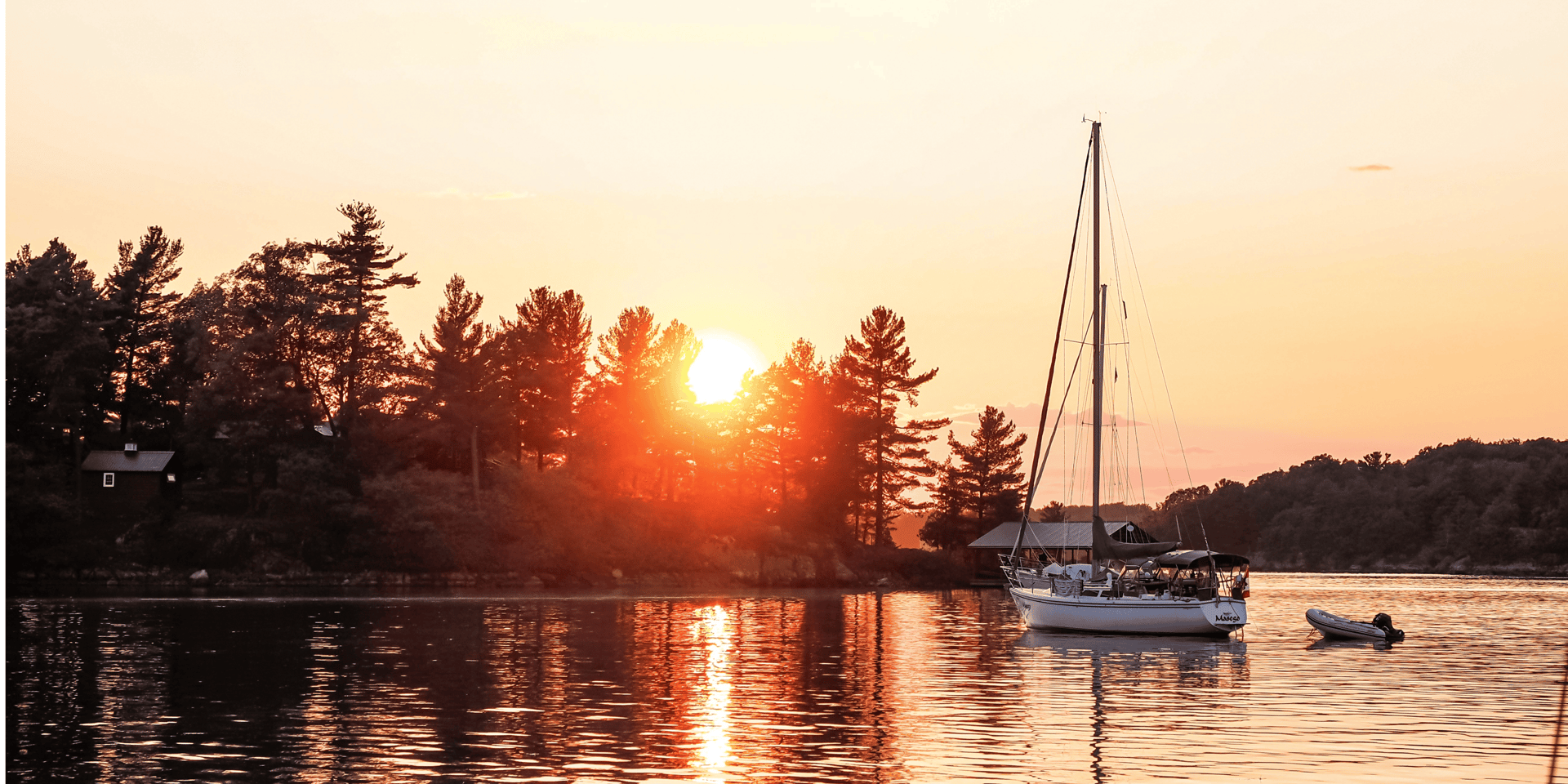 white and blue boat on water during sunset