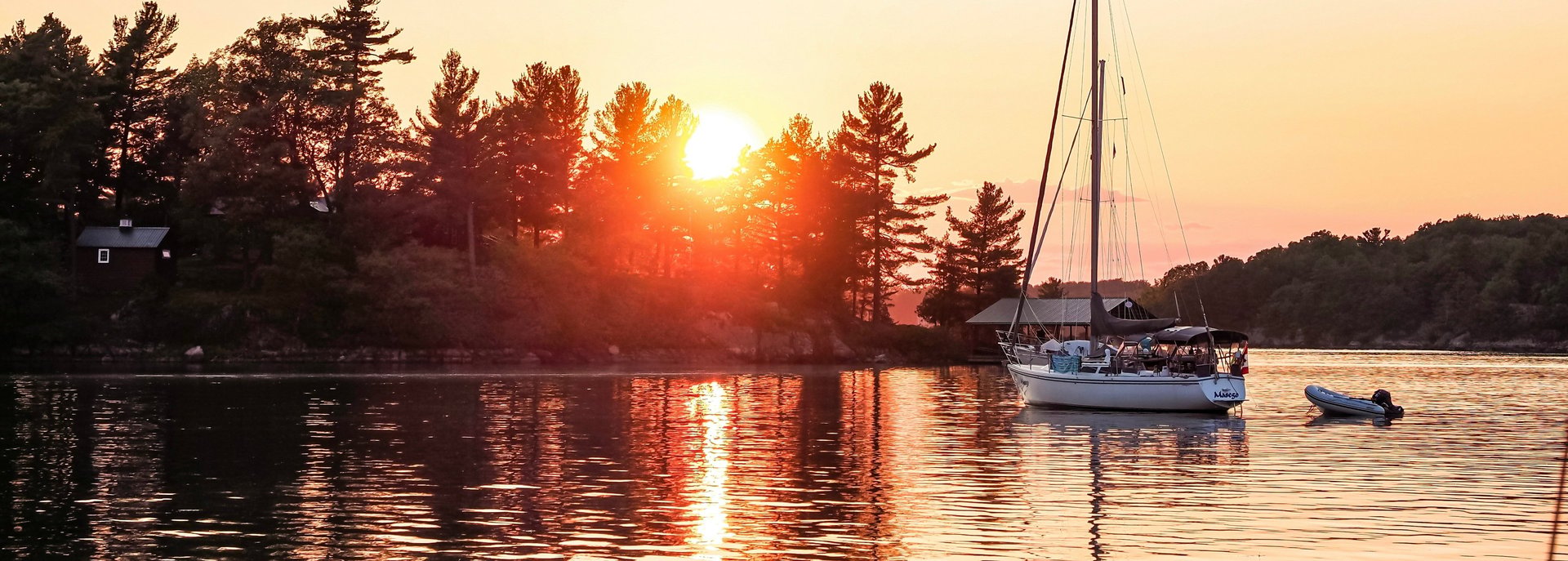 white and blue boat on water during sunset