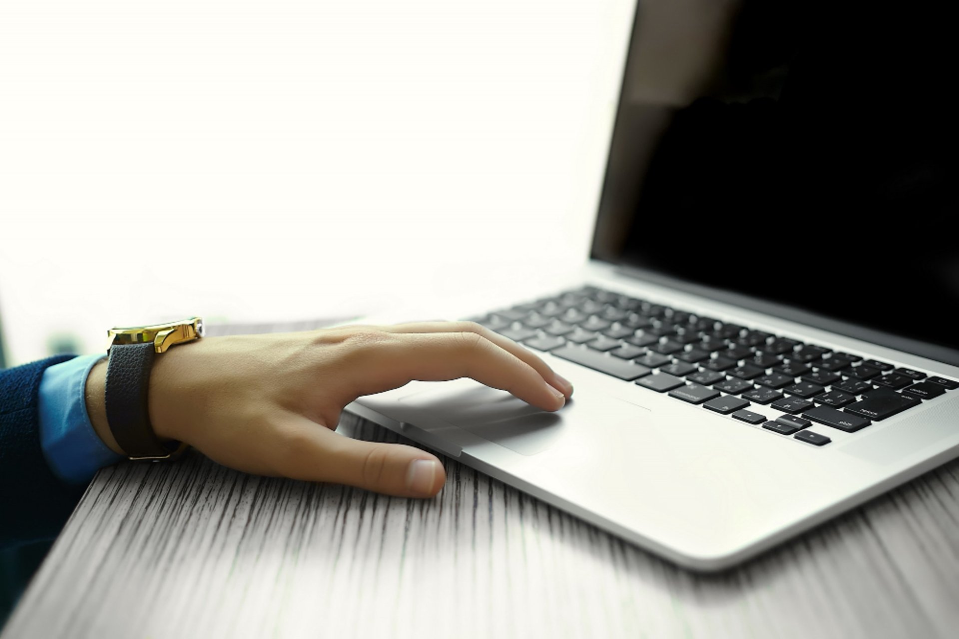 two laptop computers sitting on top of a bed