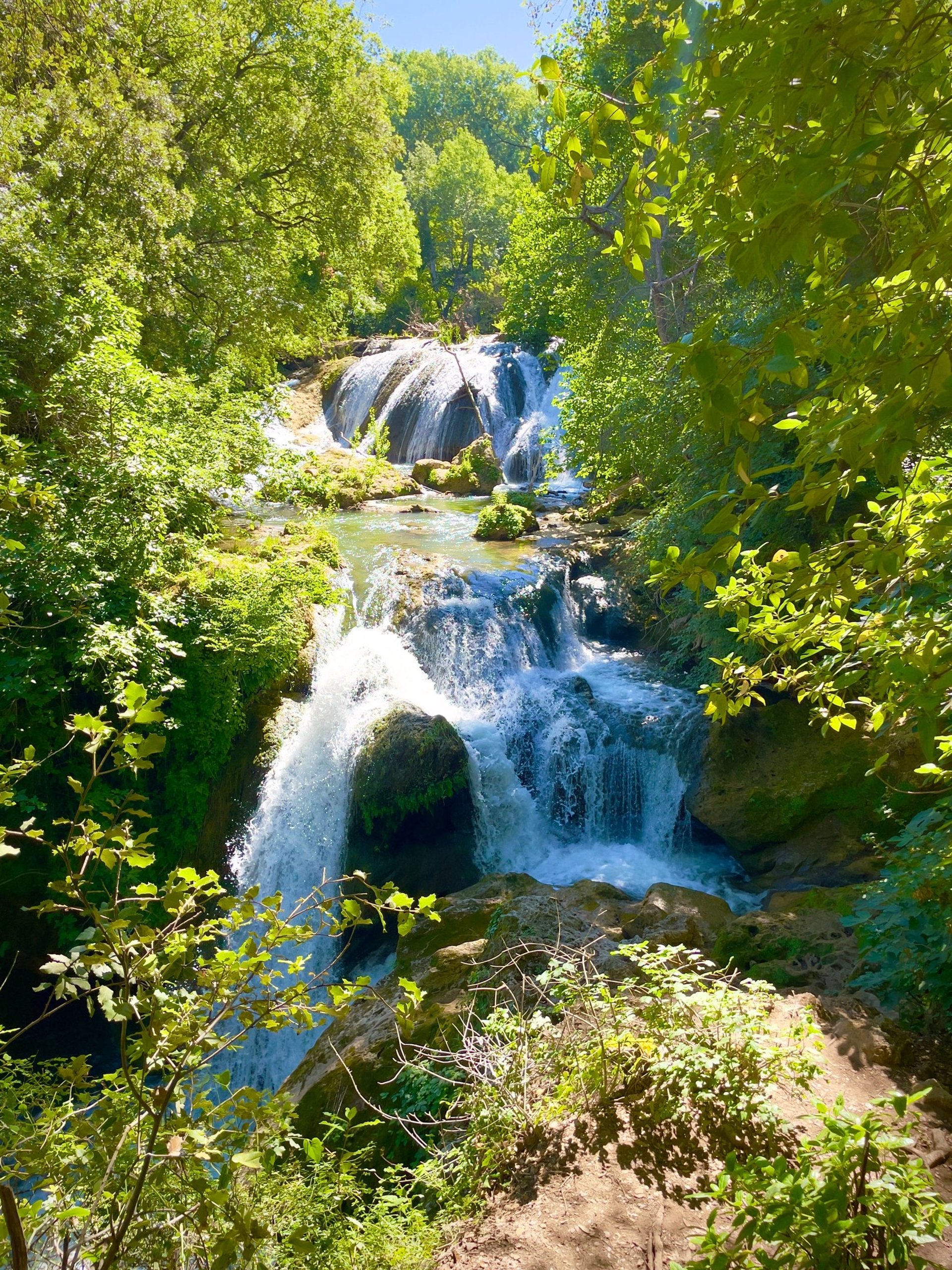waterfalls on green and gray mountain under white clouds and blue sky during daytime
