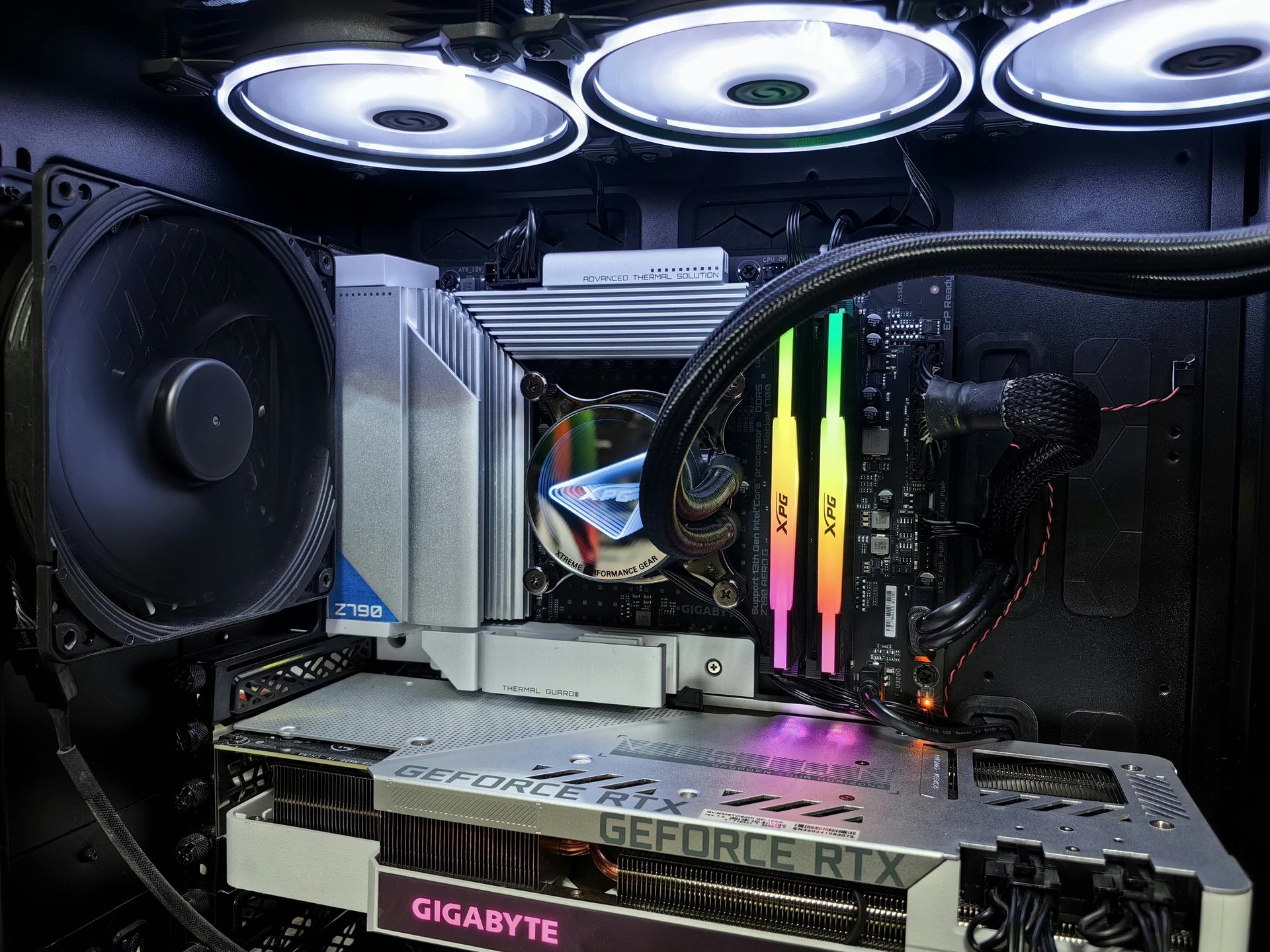 Gabinete gamer com iluminação RGB ao lado de monitor widescreen e teclado mecânico, ideal para setup profissional