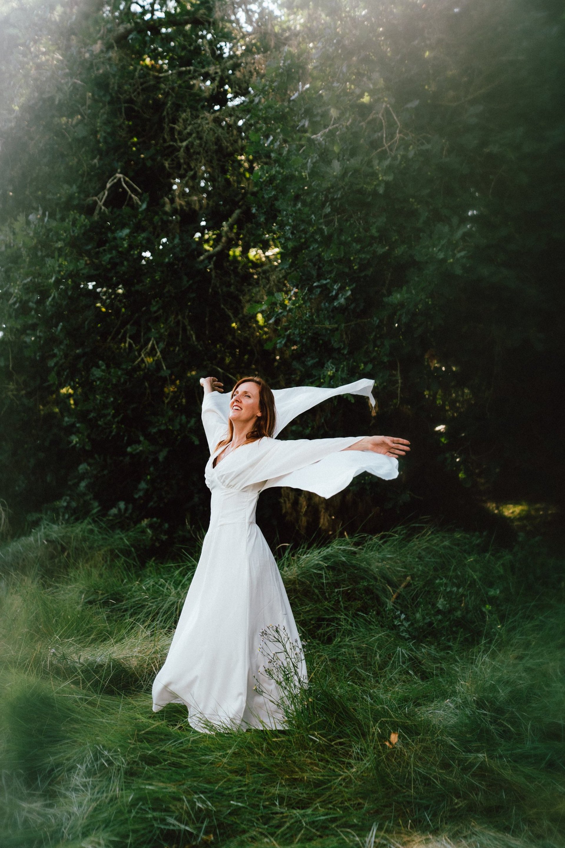 woman wearing grey midi dress holding straw hat during daytime