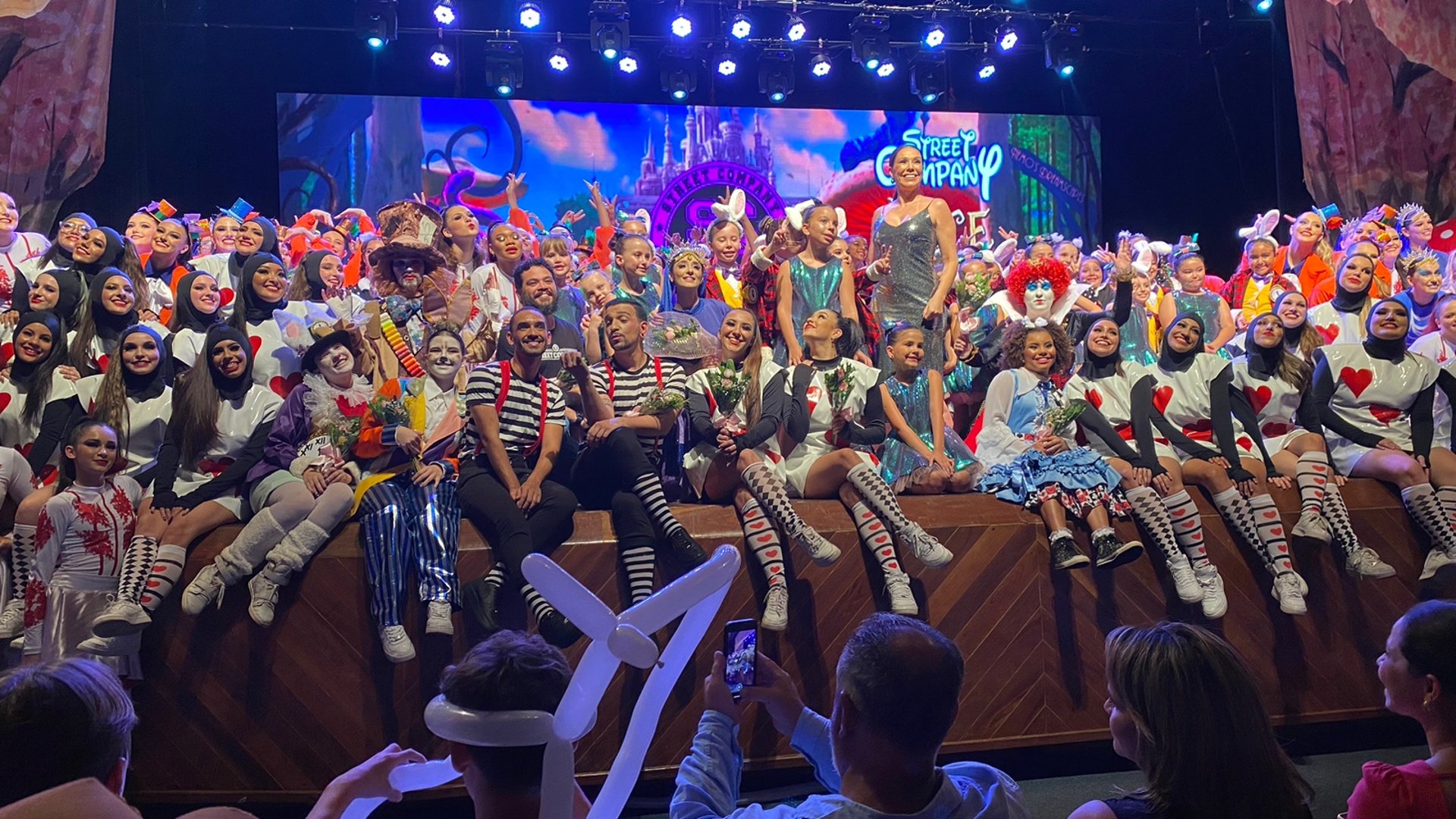 group of men in green and white shirts dancing on stage