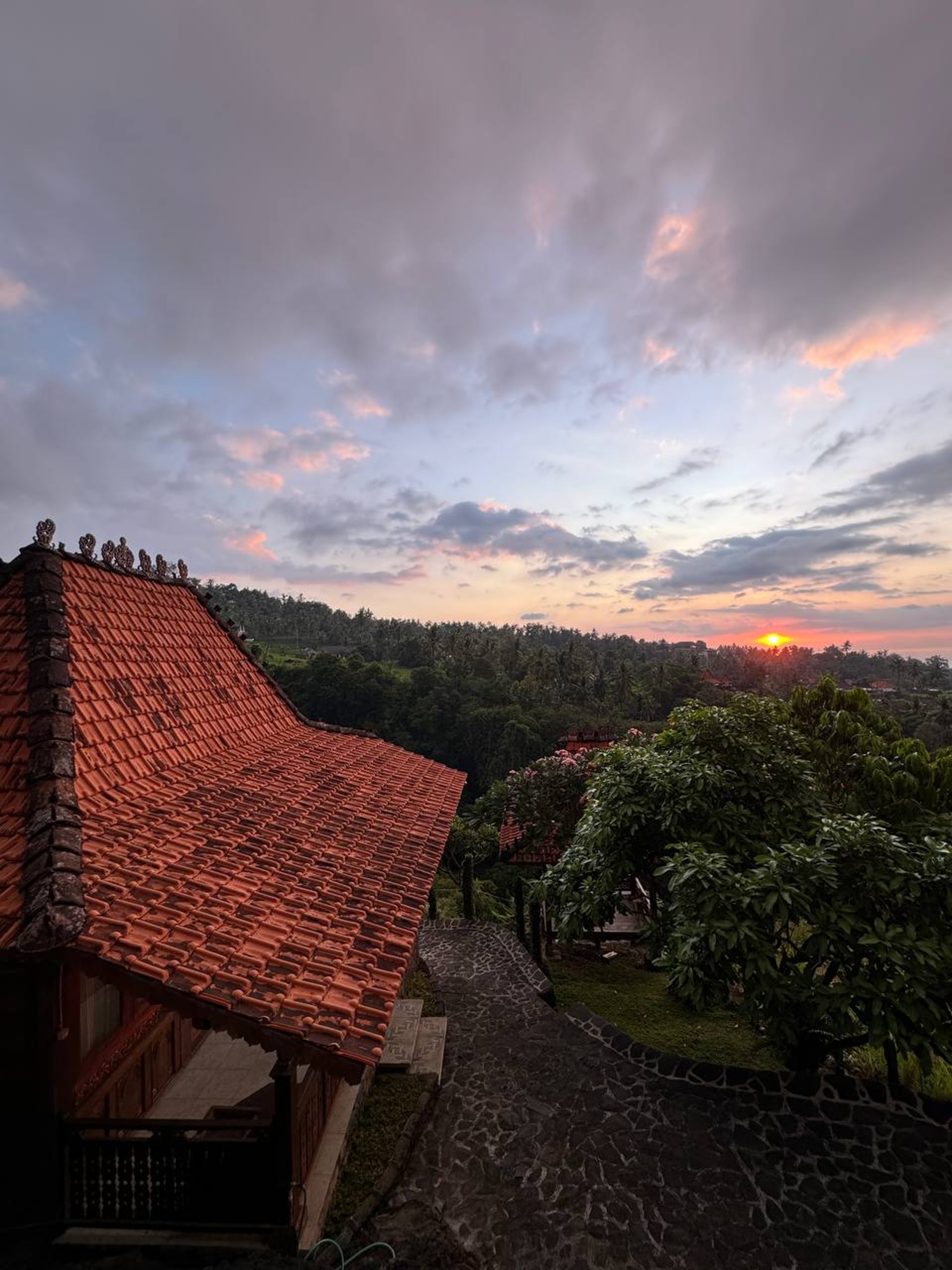 Joglo pavilion at sunset showcasing natural teak tones and elegant architectural silhouette in tropical setting