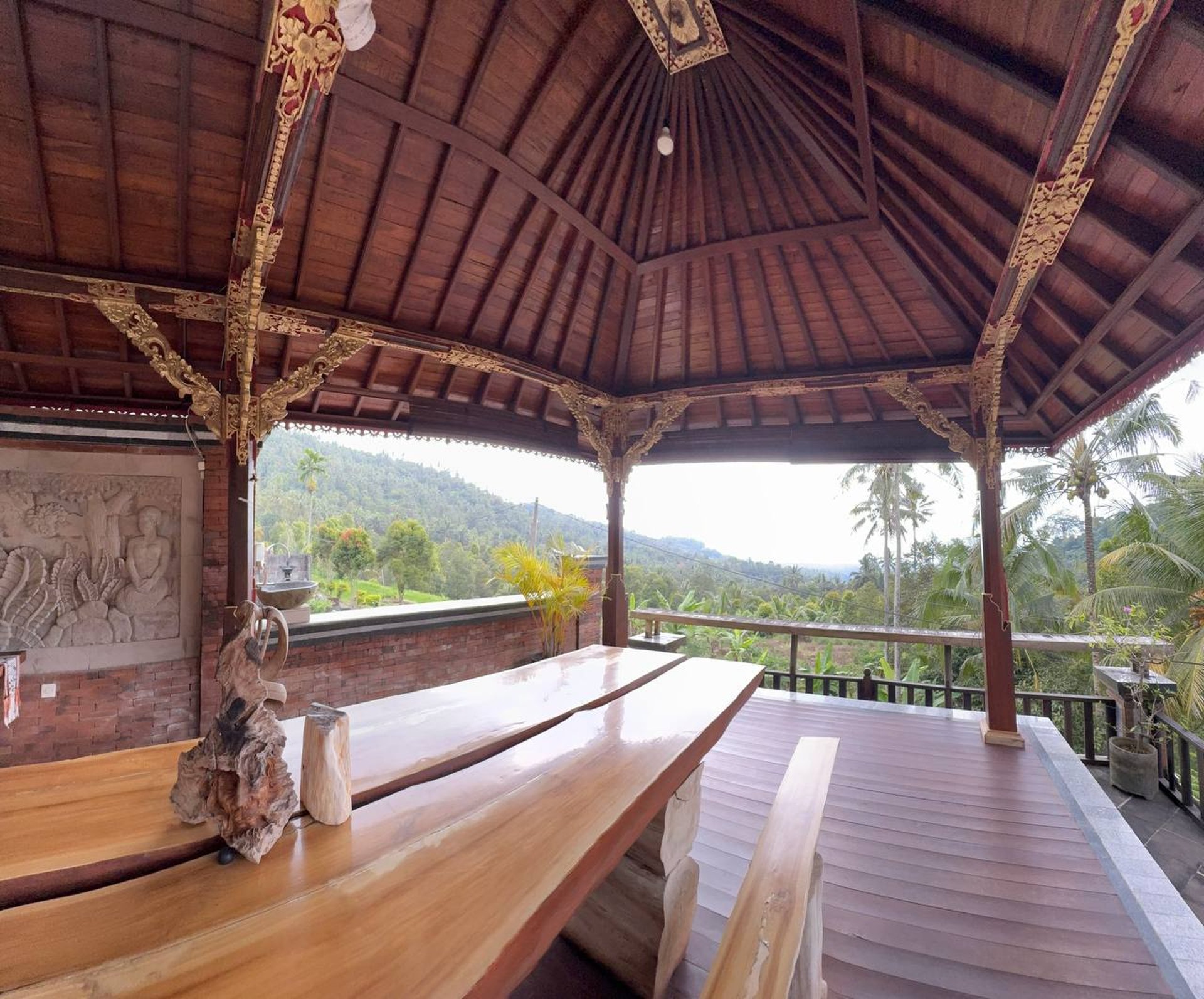 Interior of Joglo house with exposed antique teak beams creating a warm and elegant architectural space