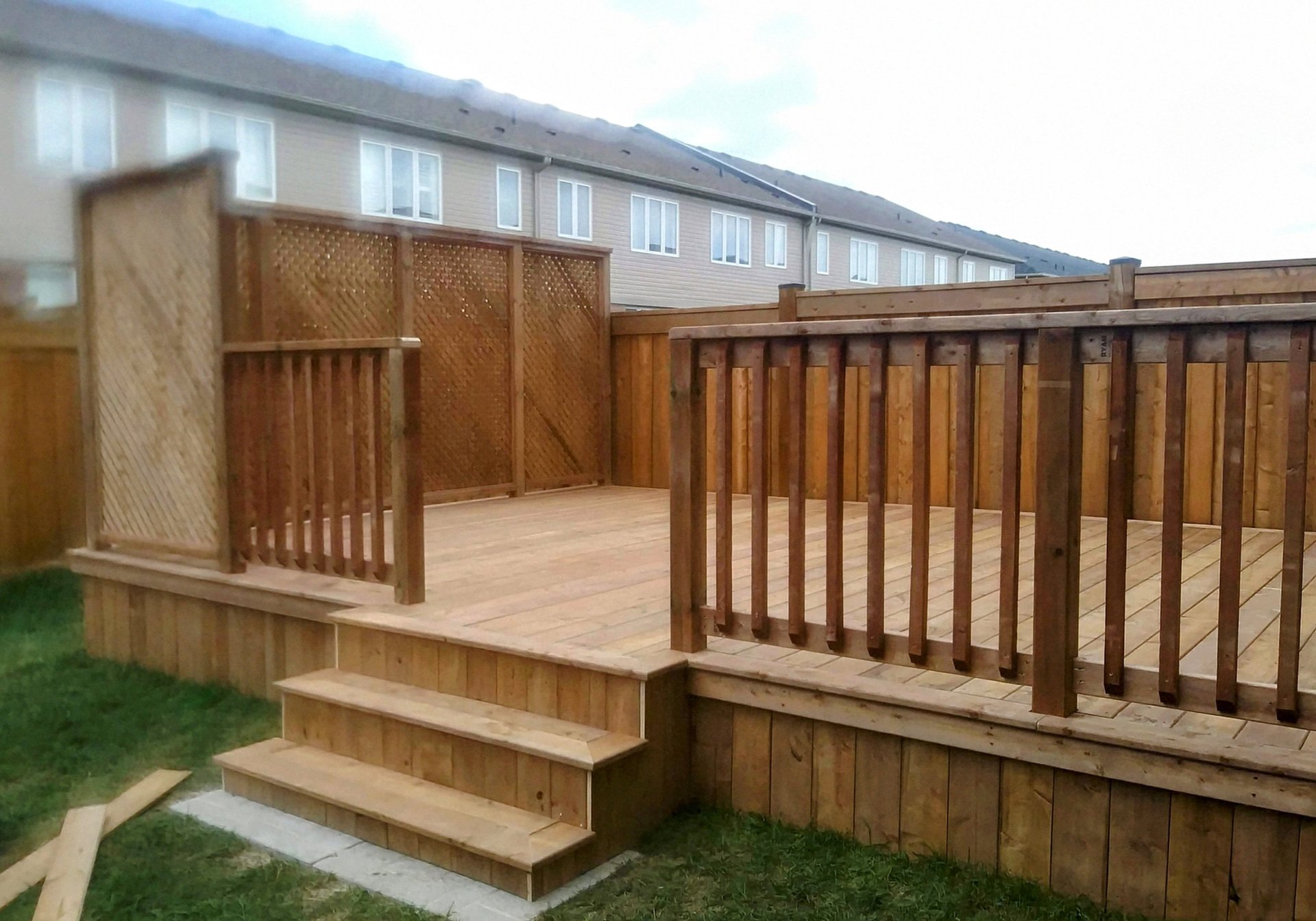 A backyard with a deck and a fence
