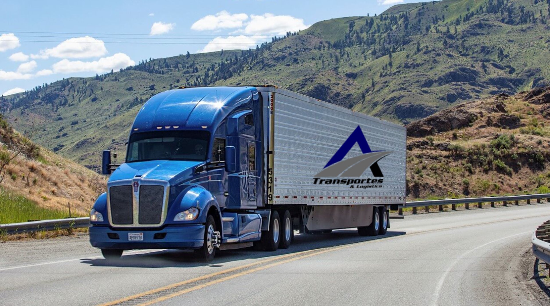 a white truck driving down a road next to a lush green field