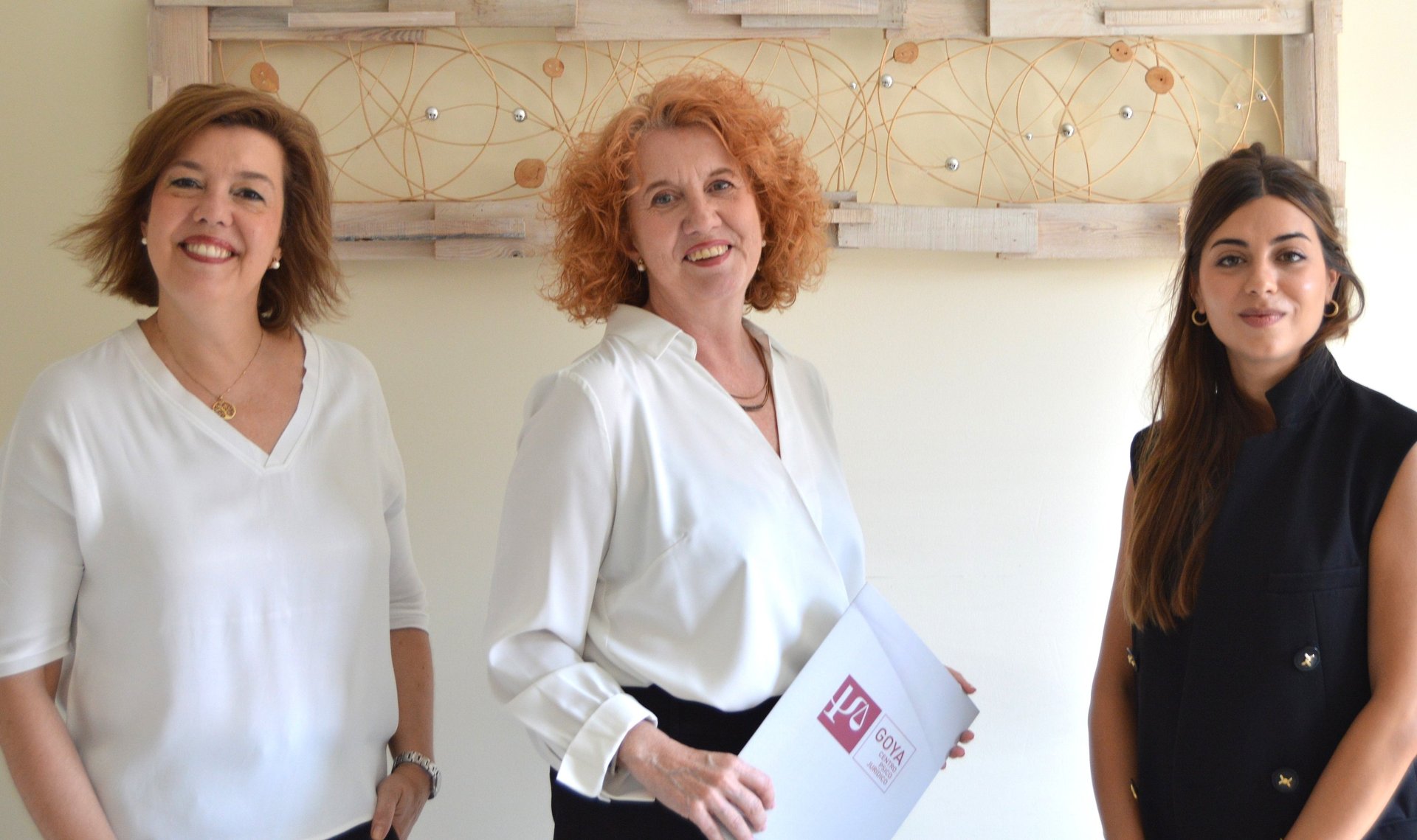 woman in blue tank top standing beside white wall