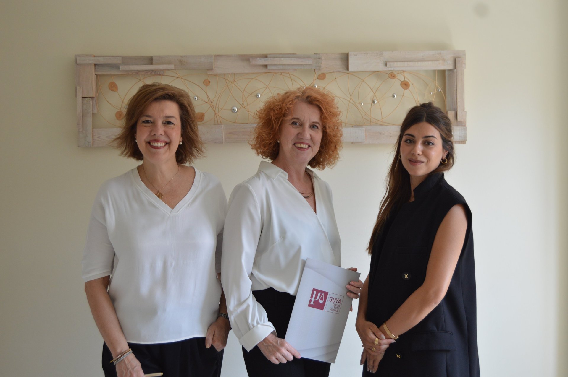 woman in blue tank top standing beside white wall