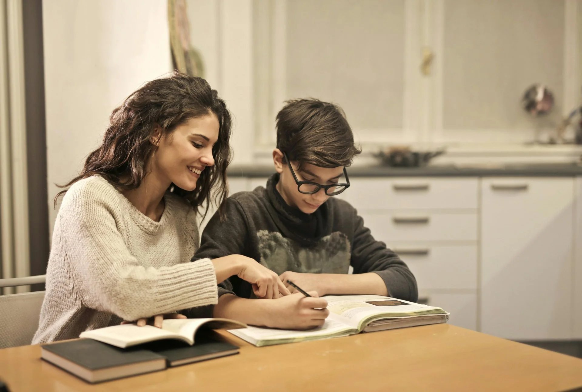 a child and mother reading on a desk in a home