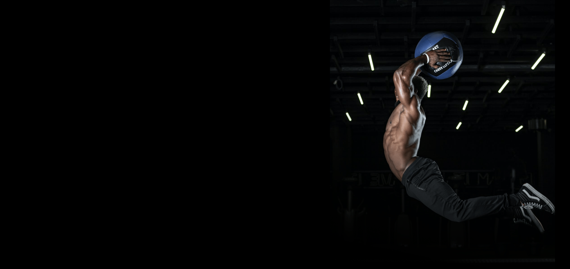woman wearing black top top holding black dumbbells standing in front of mirror