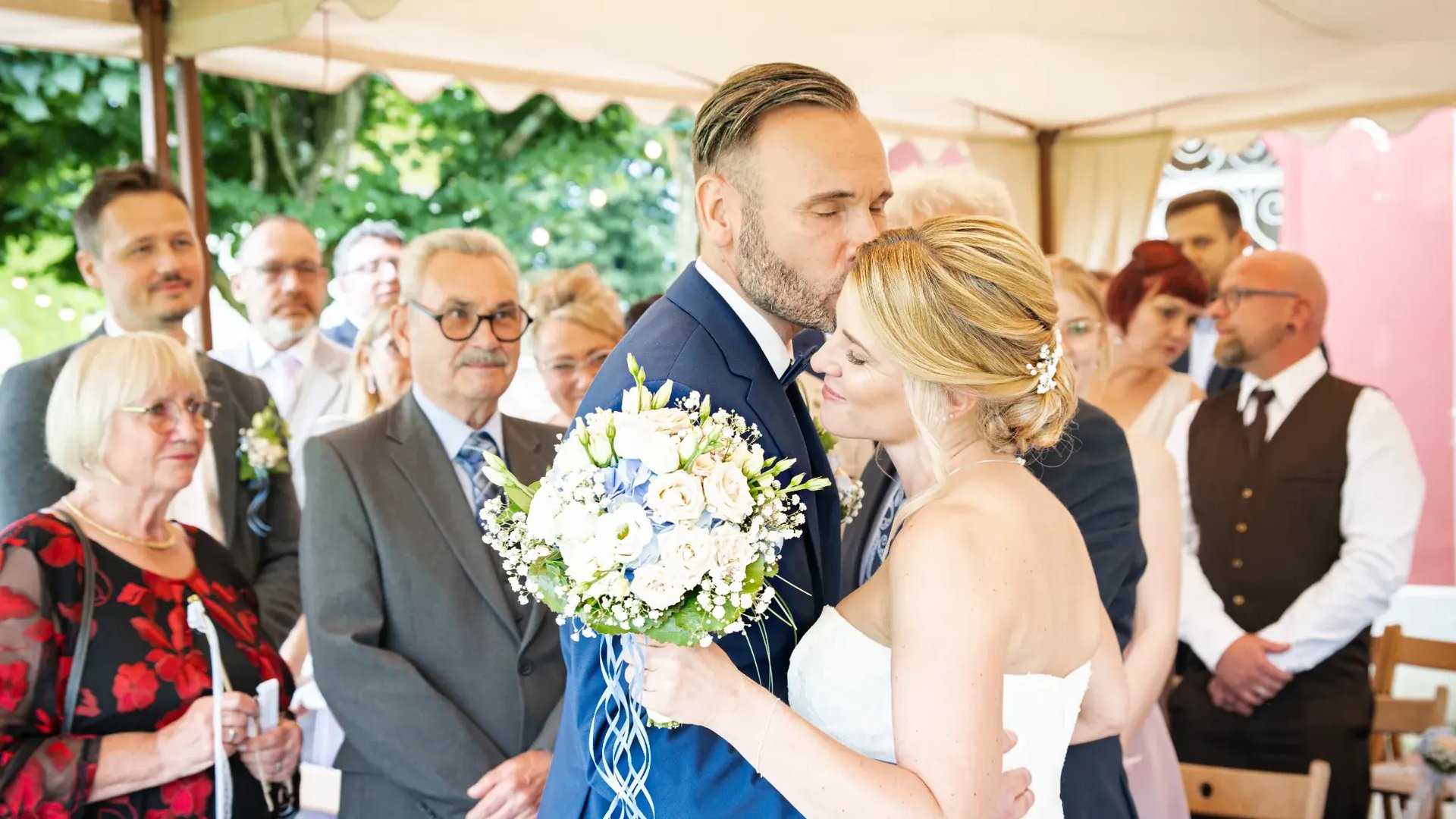 gold-colored bridal ring set on pink rose flower bouquet