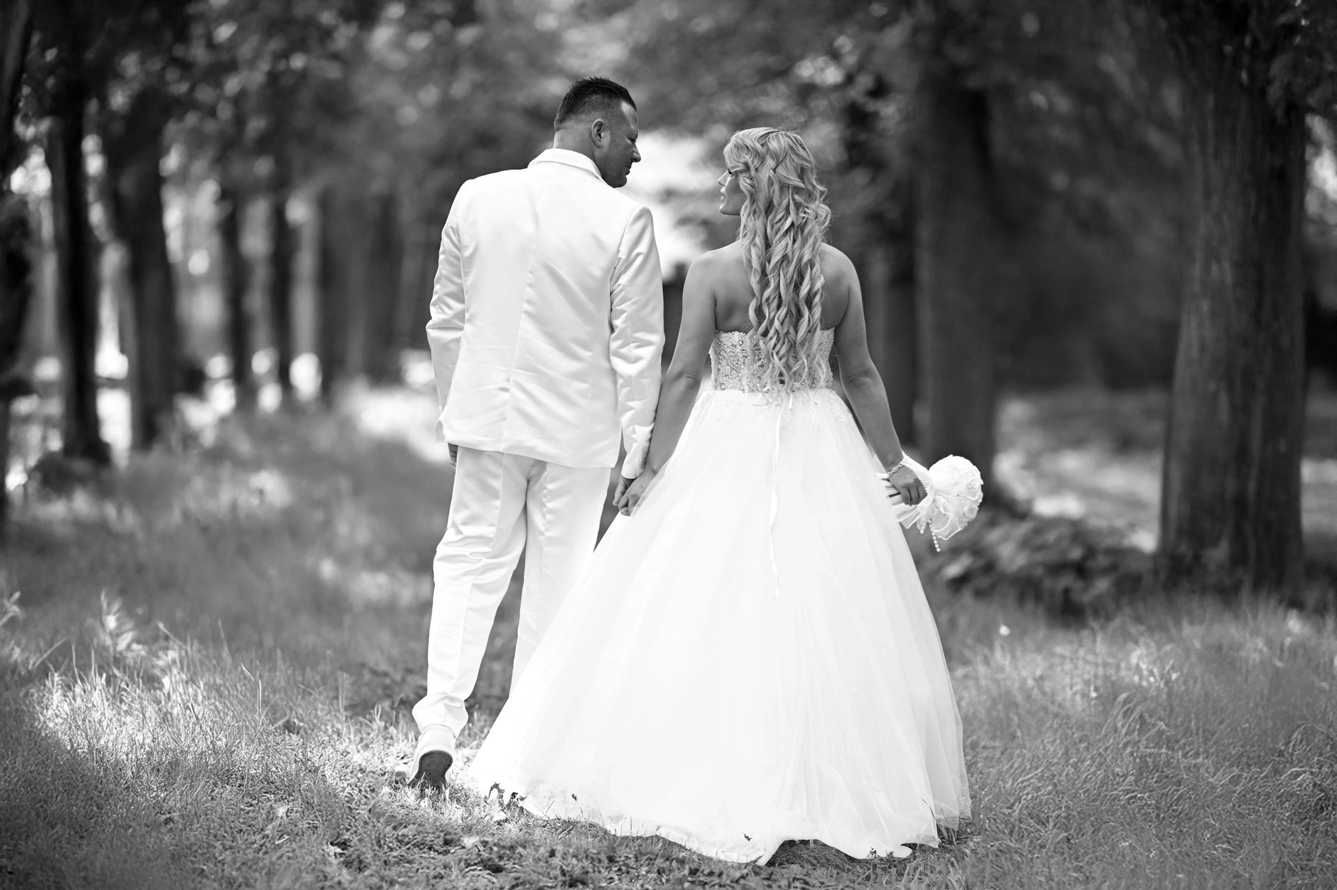 Hochzeitsgesellschaft lässt rote Luftballons auf einem Steg am See steigen – Gruppenmoment einer Hochzeitsreportage.