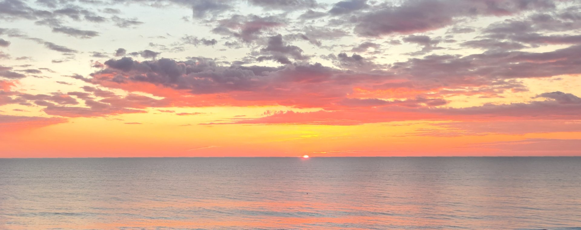 A group of people walking along a beach next to the ocean