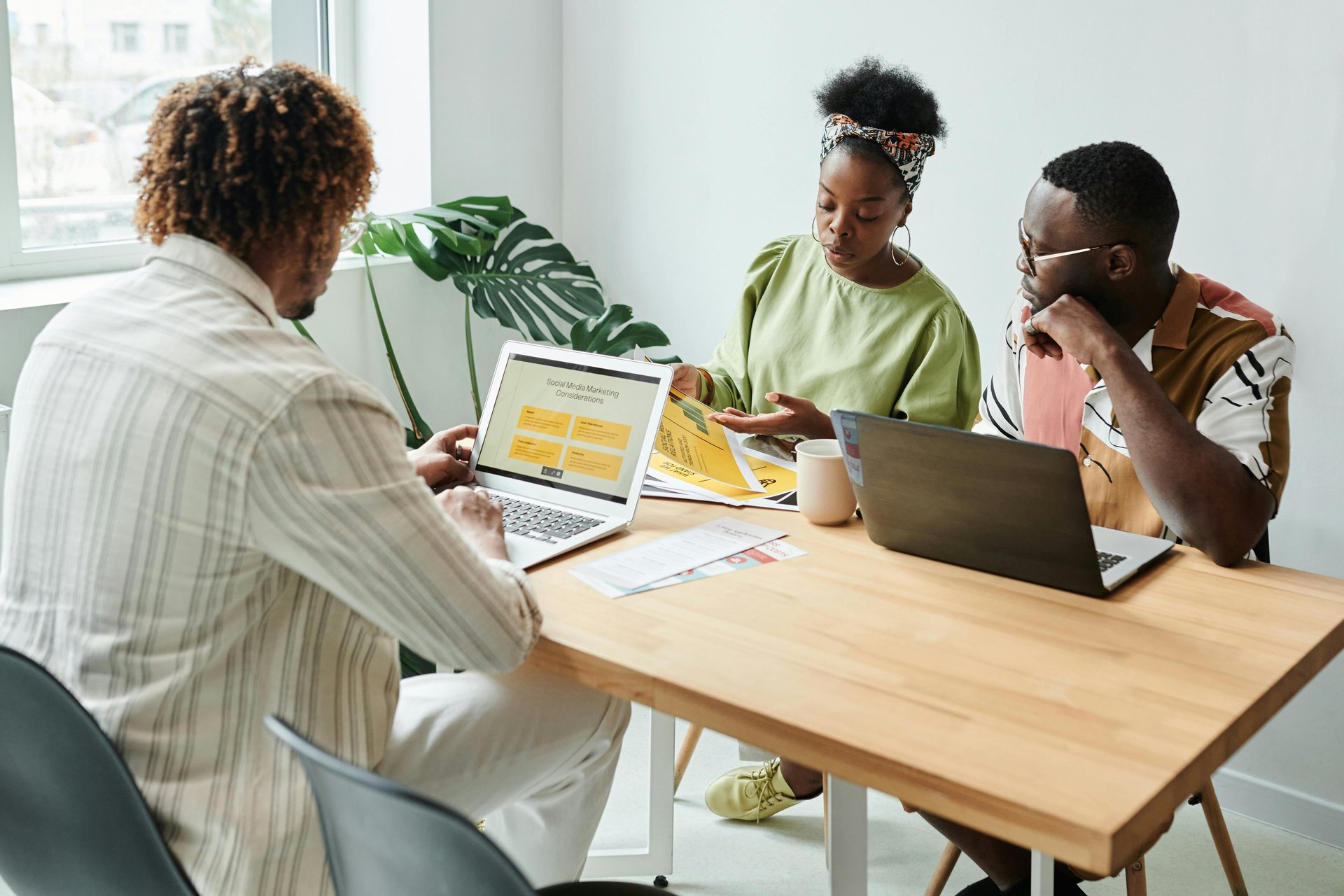 Three co-workers sitting together in the office with Surface laptop on the table