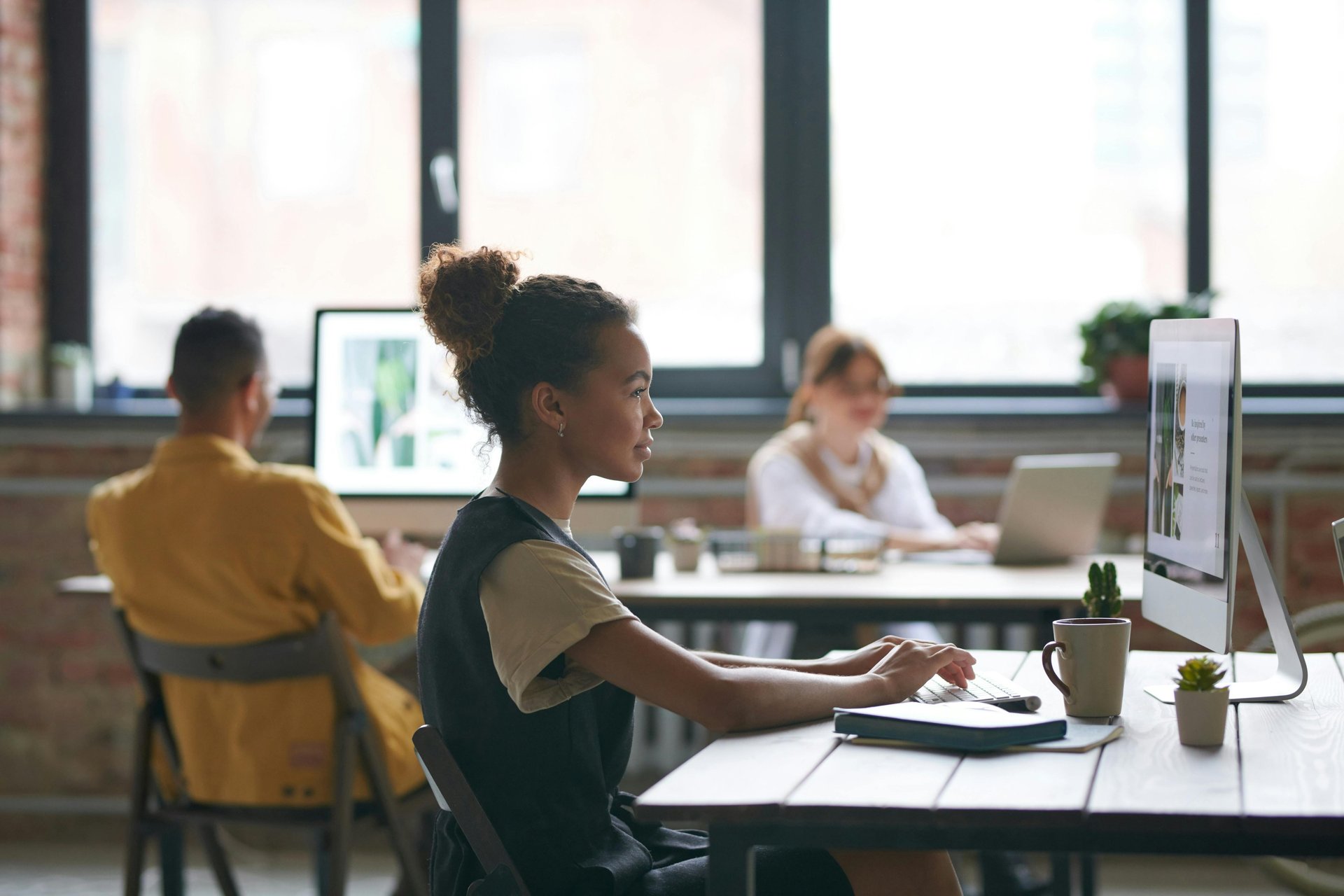 Three co-workers sitting together in the office with Surface laptop on the table