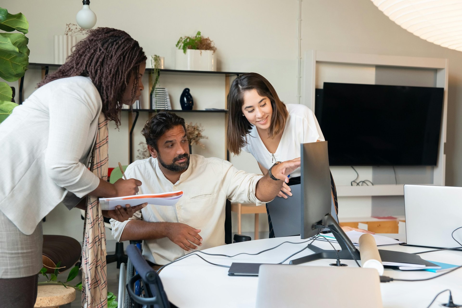 Three co-workers sitting together in the office with Surface laptop on the table