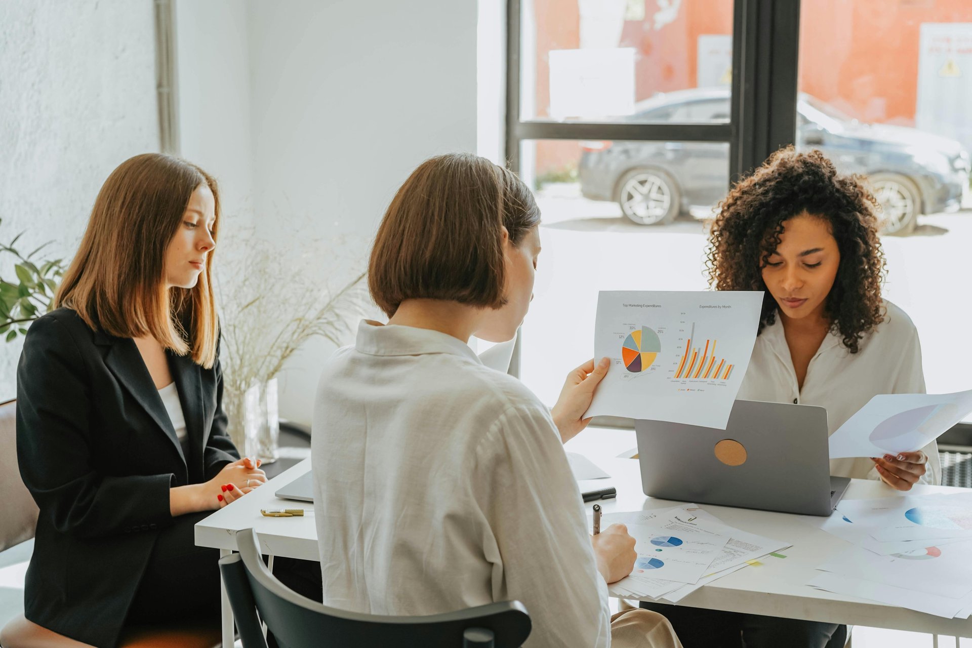 Three co-workers sitting together in the office with Surface laptop on the table