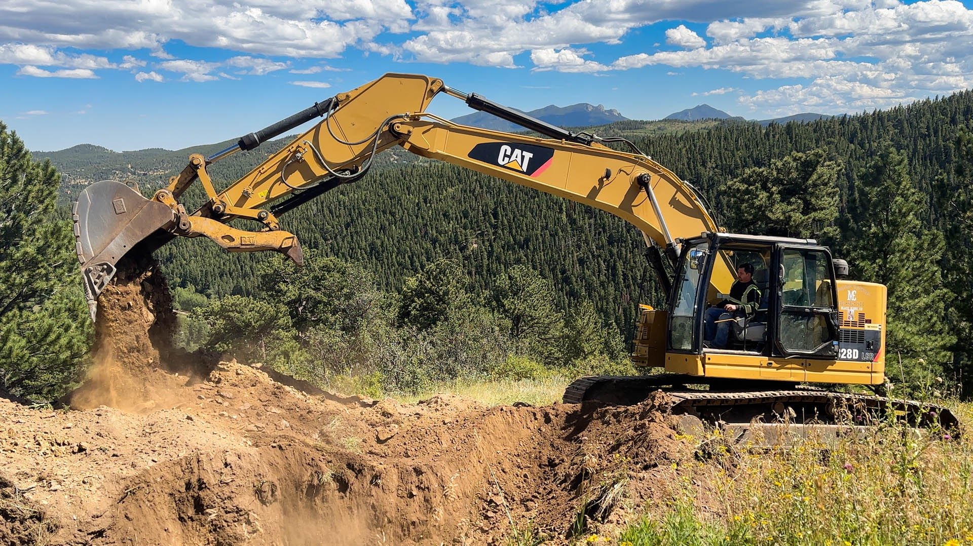 Drone photo of a CAT excavator grading a hillside for a residential project in Boulder.