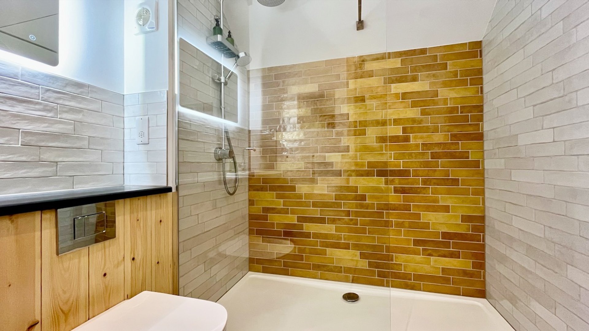 the generous shower room with brightly coloured tiles