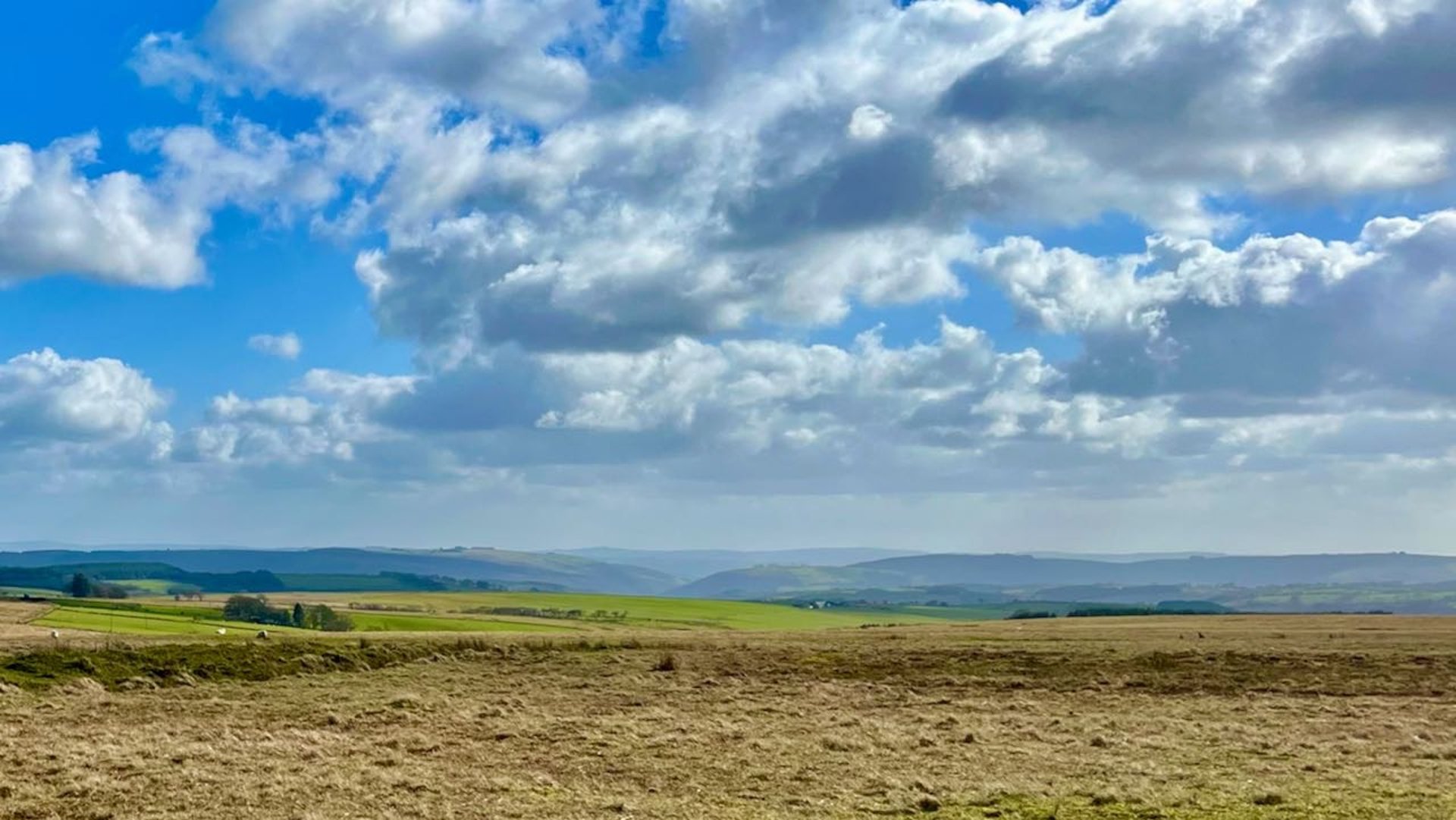 a view of the llanllwni mountain with hills in the distance and dramatic sky