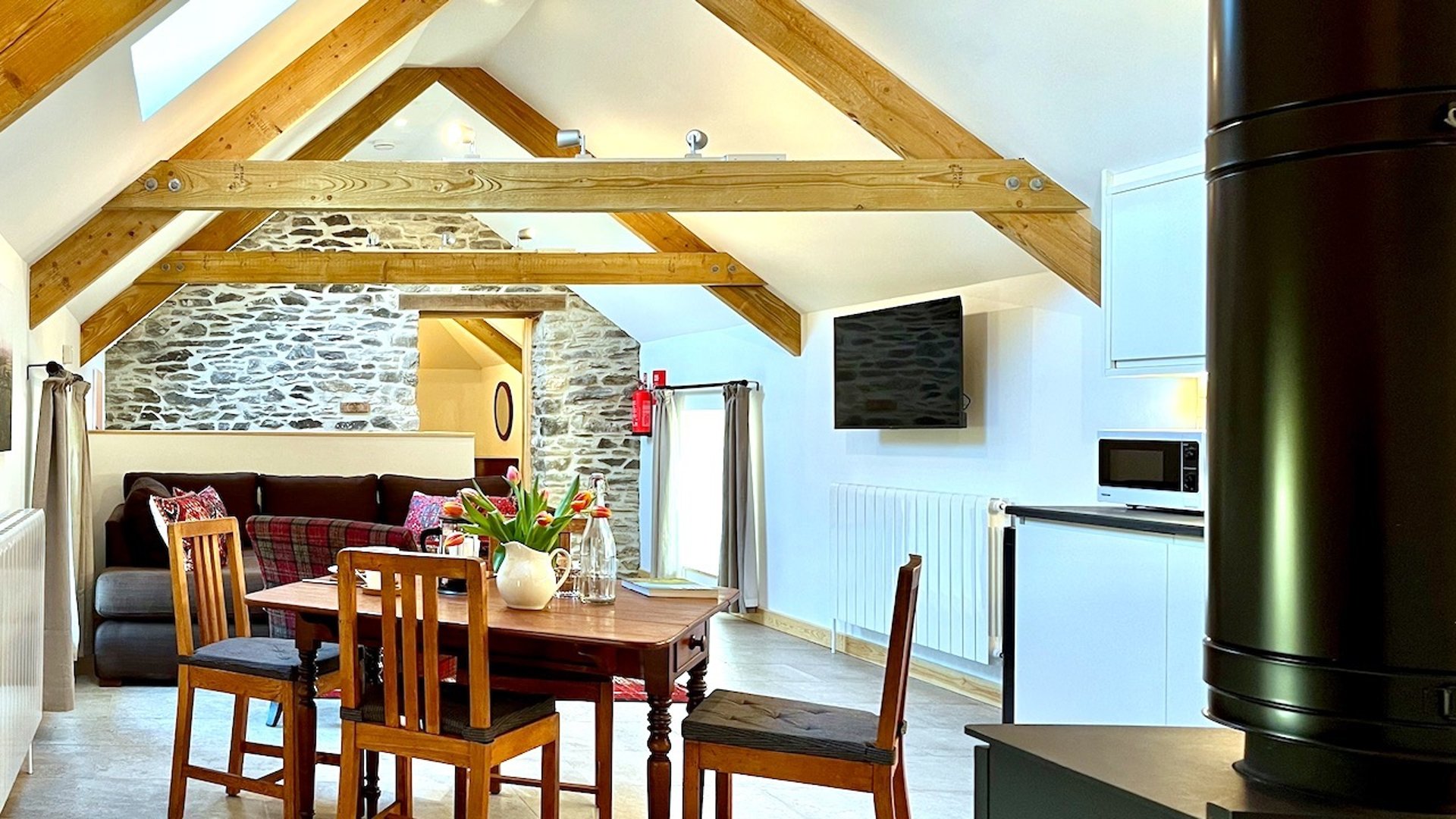 a high vaulted room with table and chairs and timber beams