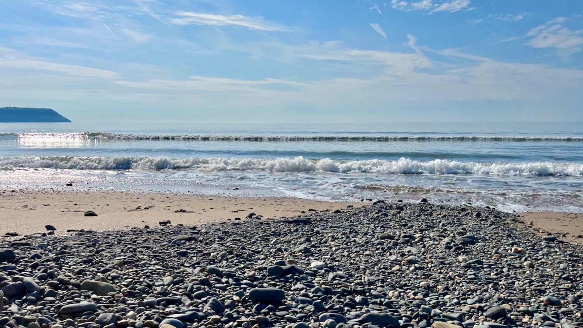 a view of a beautiful beach with the waves crashing in