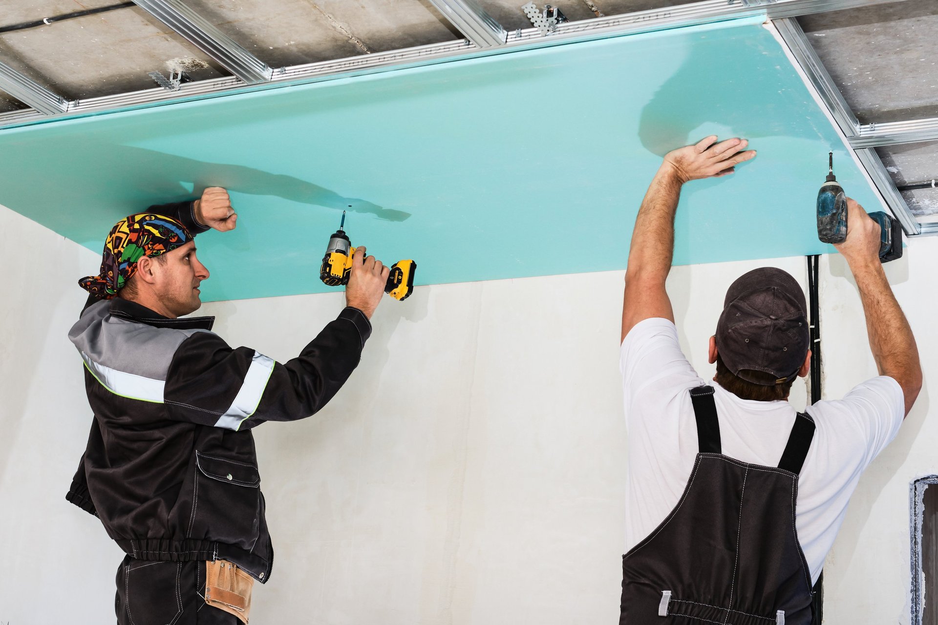a man painting a wall with a paint roller