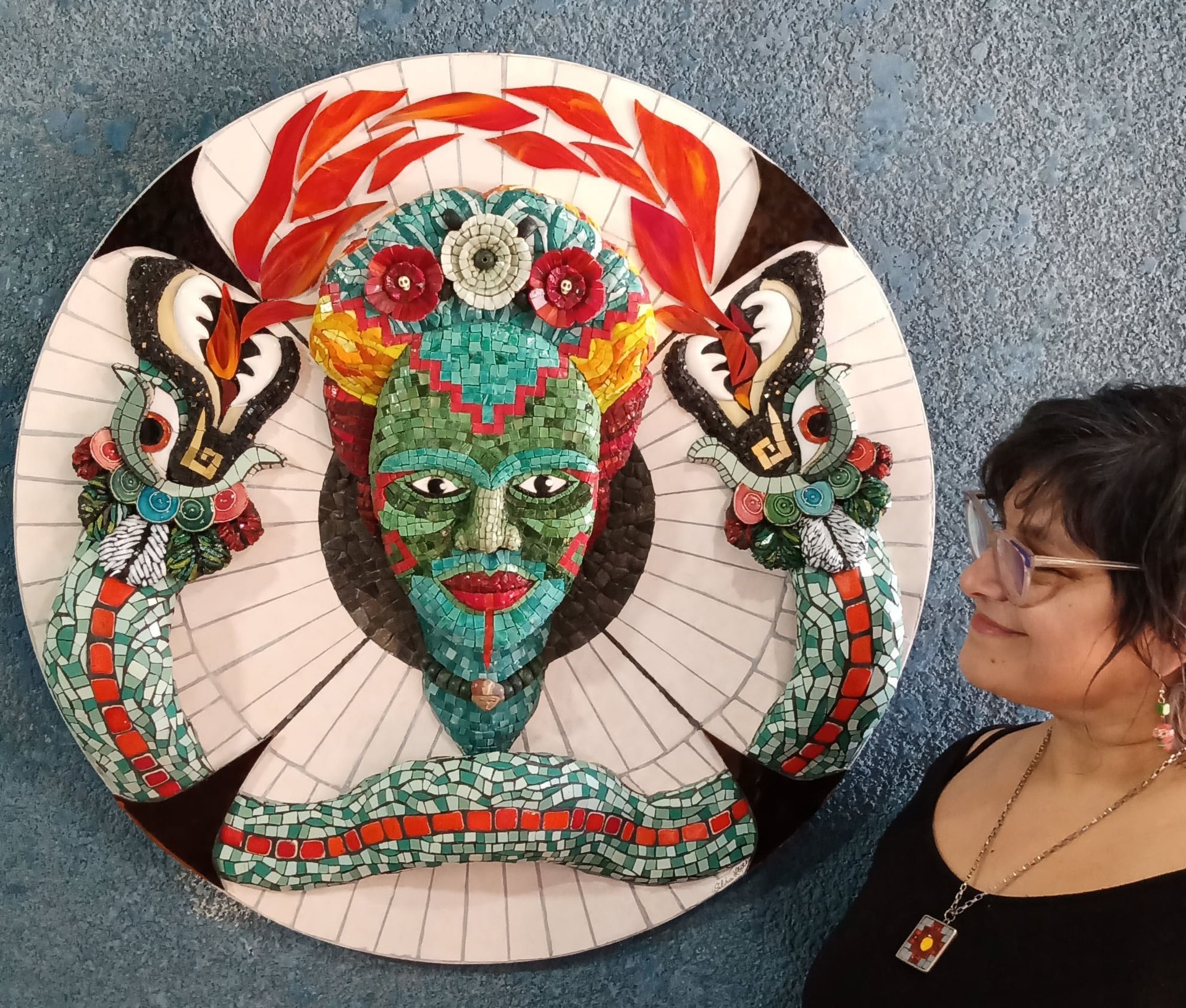 a close up of a mosaic with a painting on it