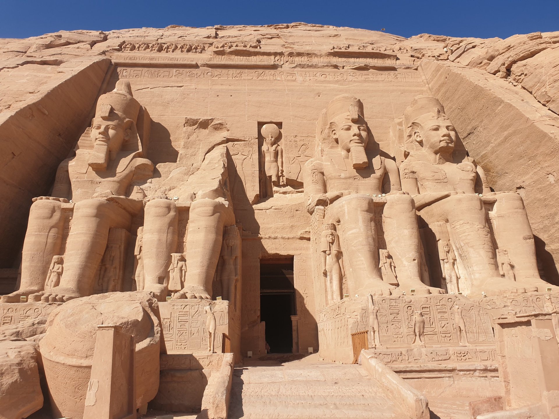 Ancient egyptian temple stands beside the calm water.