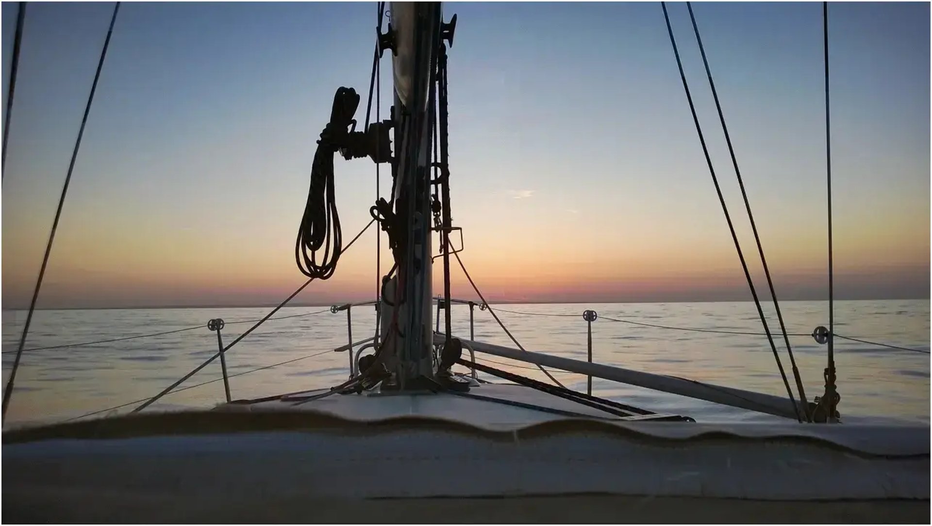 Voilier en navigation par mer calme au coucher du soleil