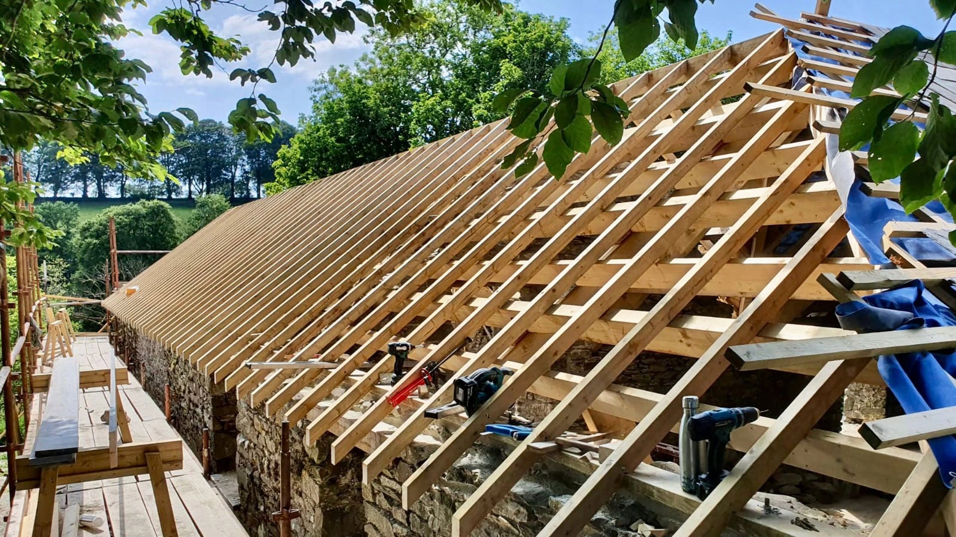 The barn with the new roof timbers covering the old stone walls.