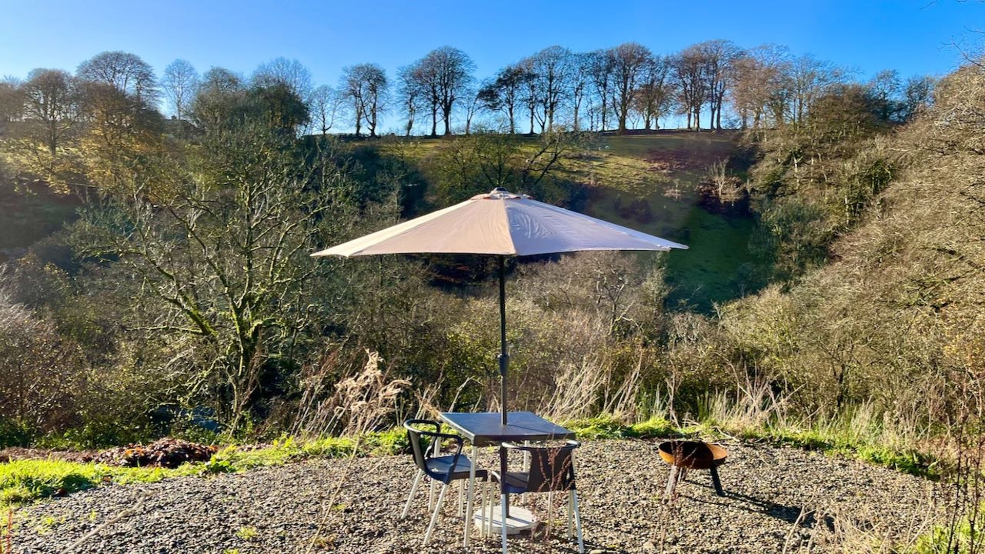 s seating area with parasol overlooking the valley