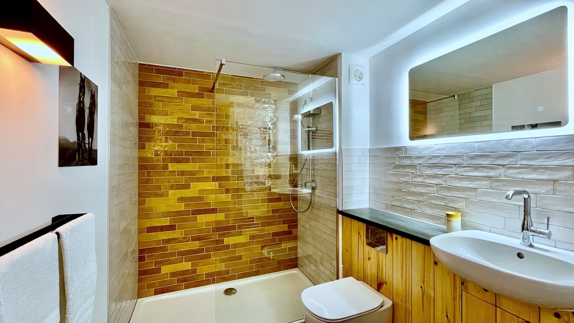 a brightly lit shower room with colourful tiles