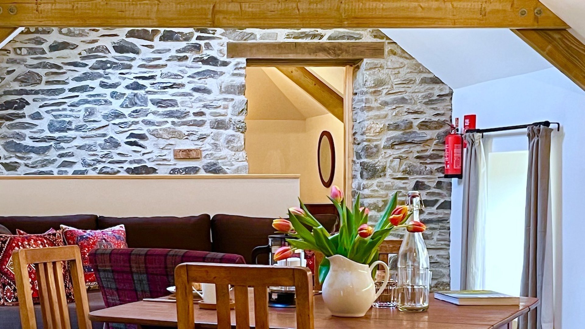 a table with red tulips and stone wall behind