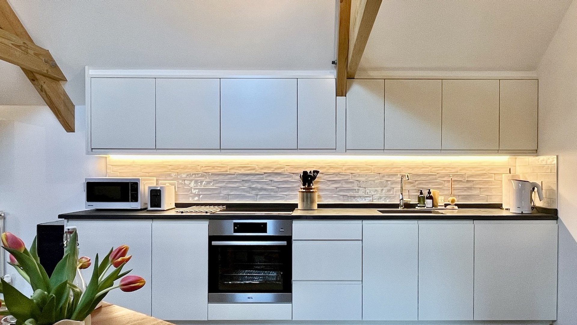 clean white kitchen units with lighting under the wall cupboards