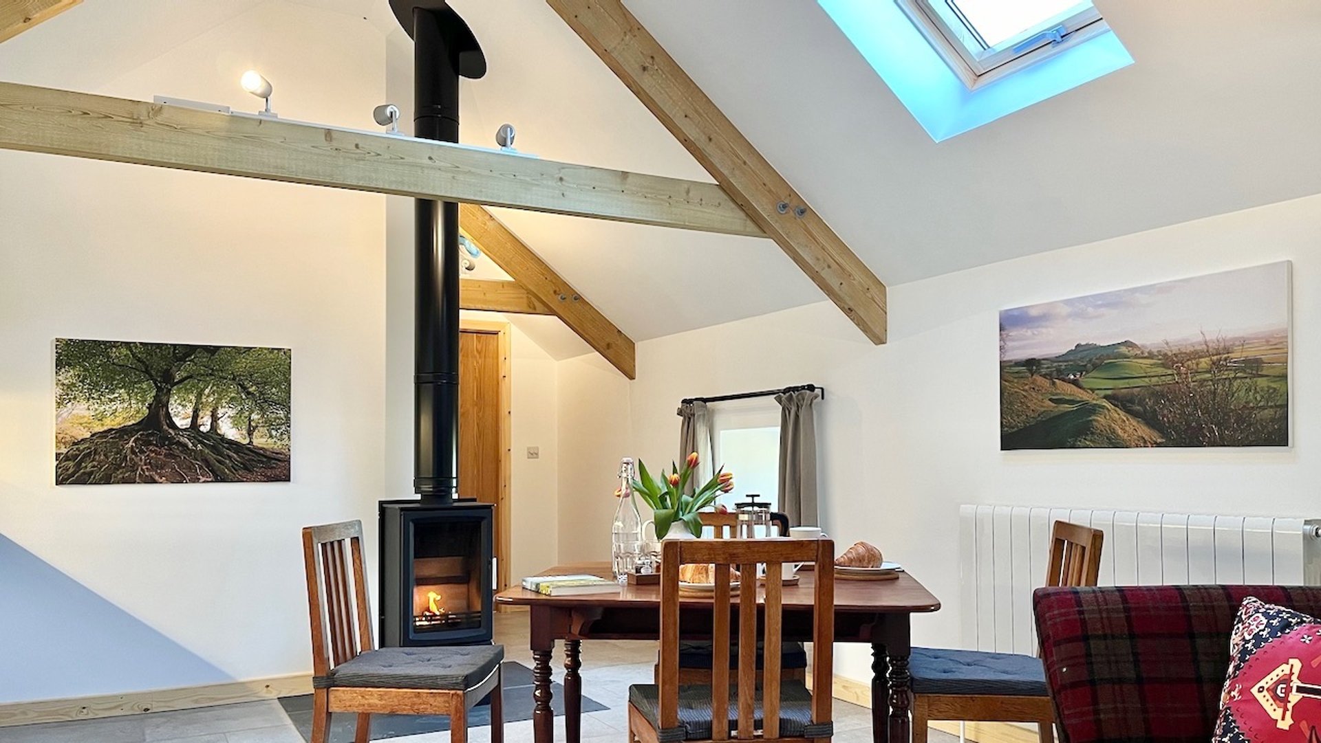 high vaulted room with wood burning stove and table and chairs